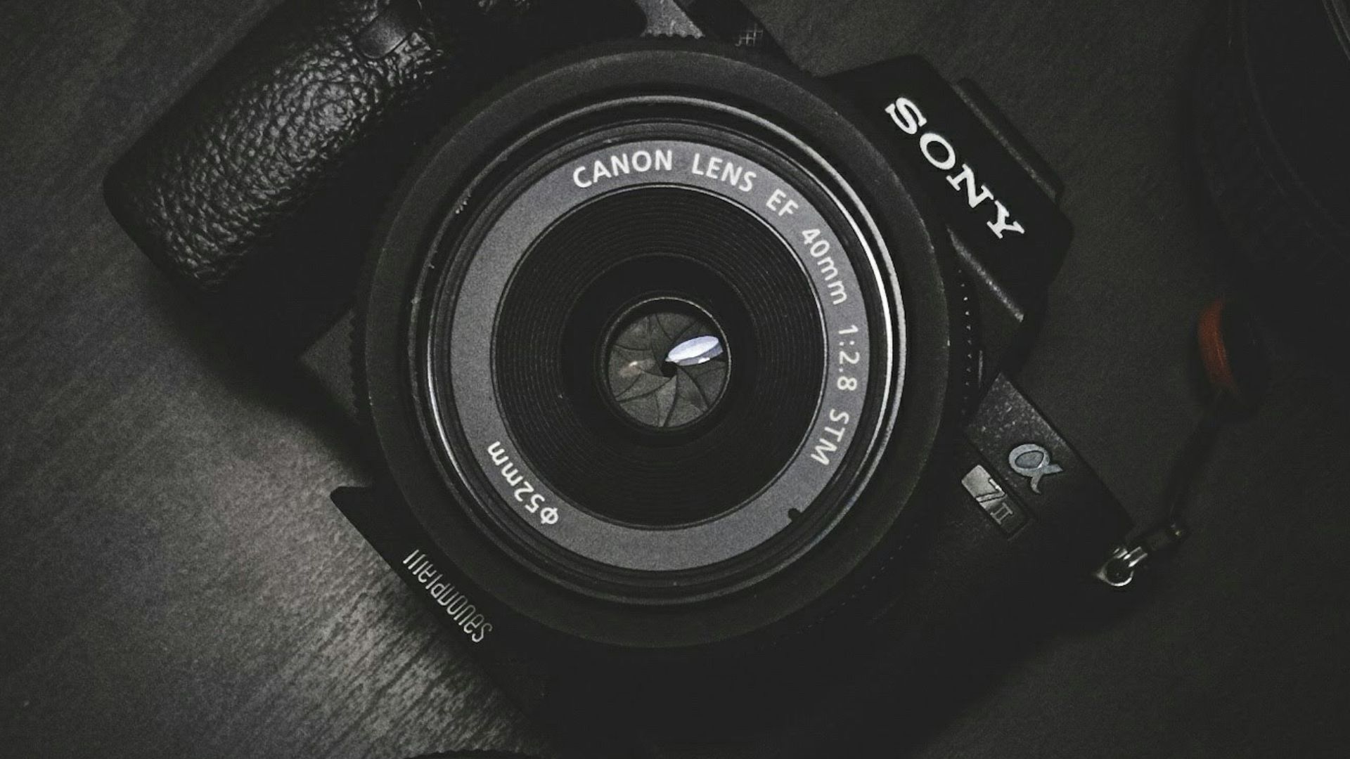 flat lay photography of black Sony DSLR camera on black surface