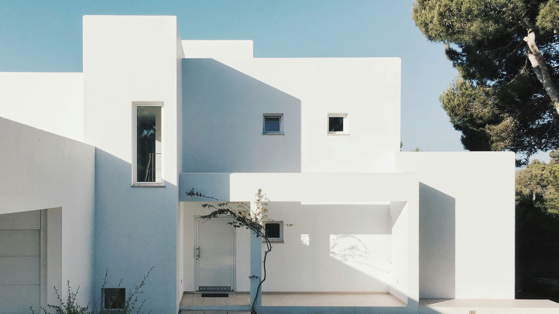 white concrete house near green tree during daytime