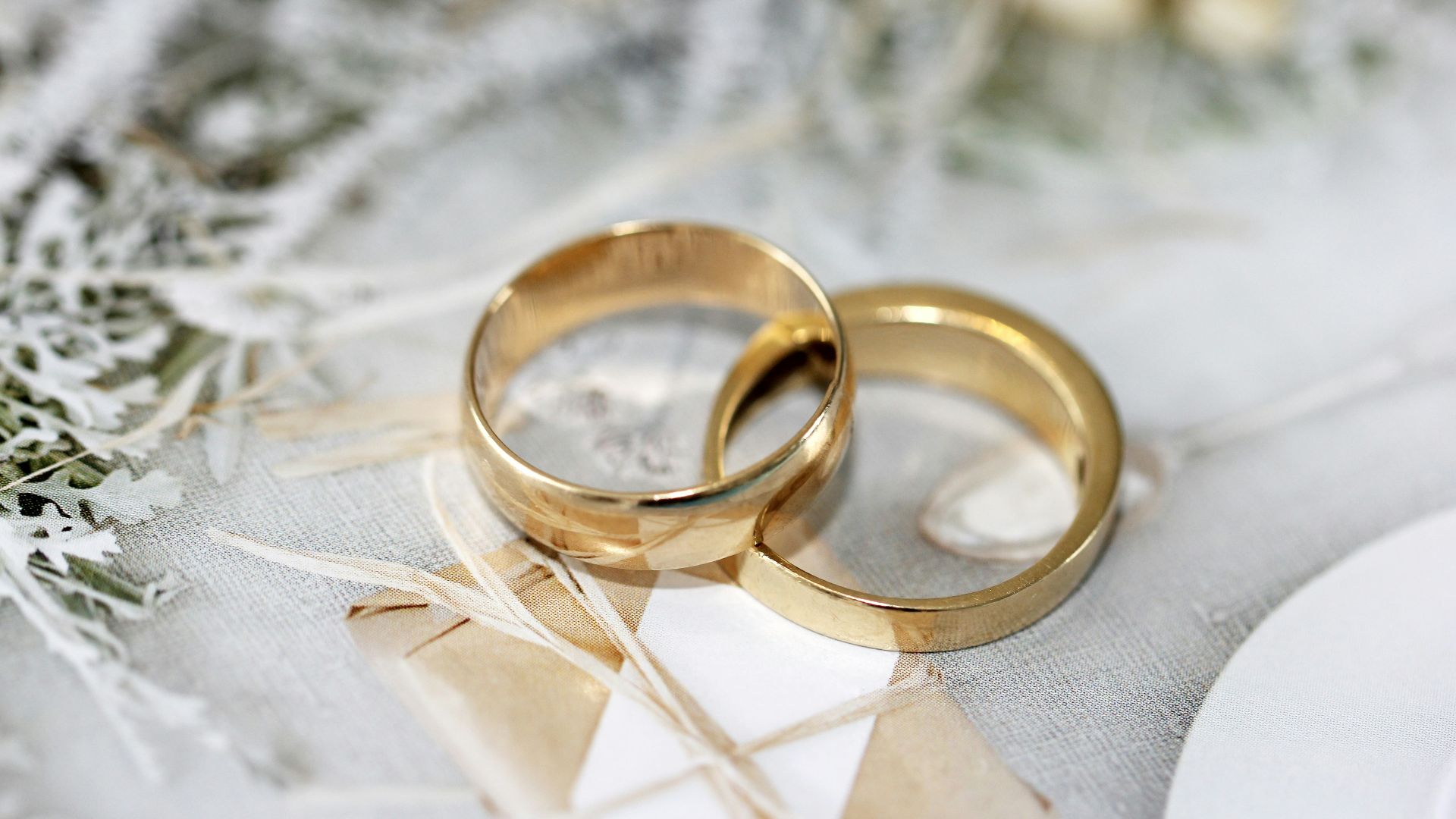 gold wedding band on white textile