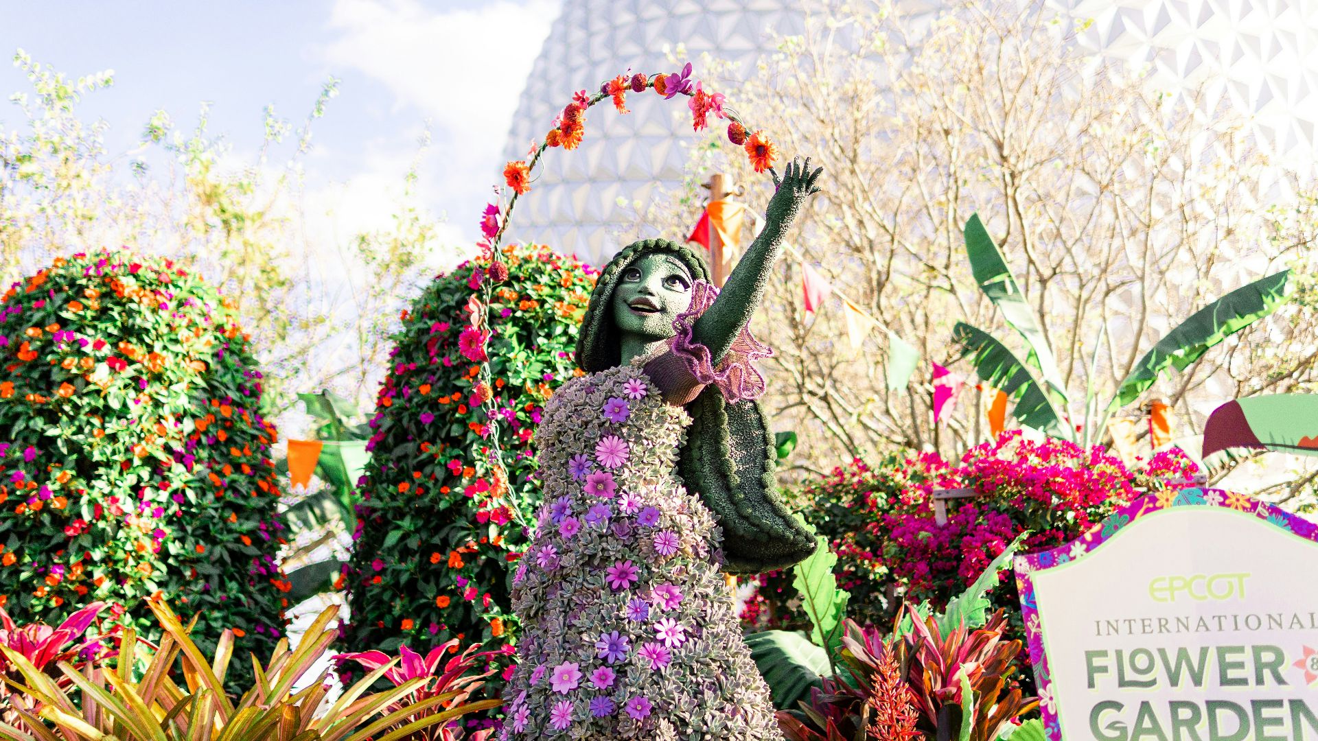 a statue of a woman in a flower garden