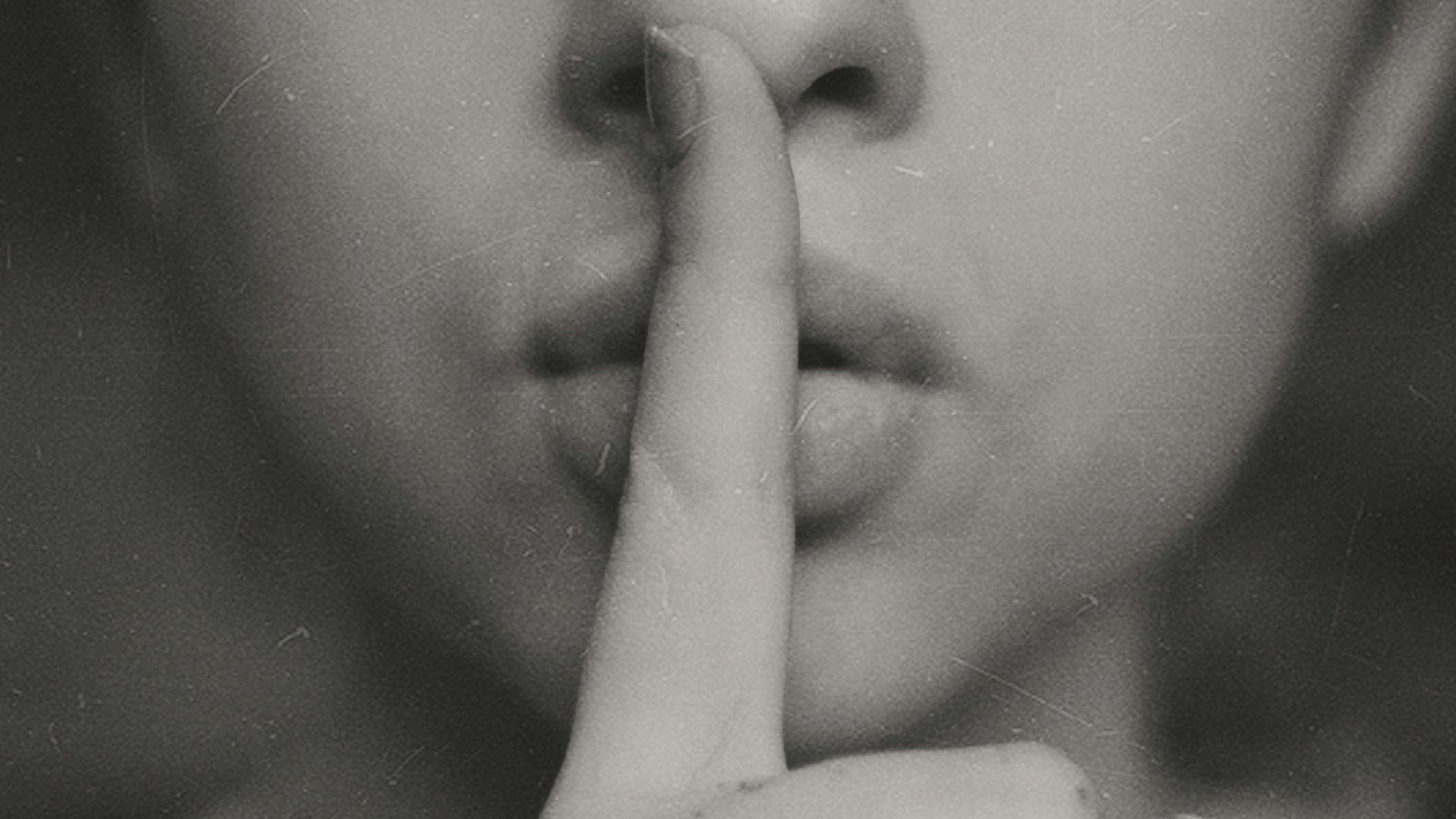 grayscale photo of woman doing silent hand sign