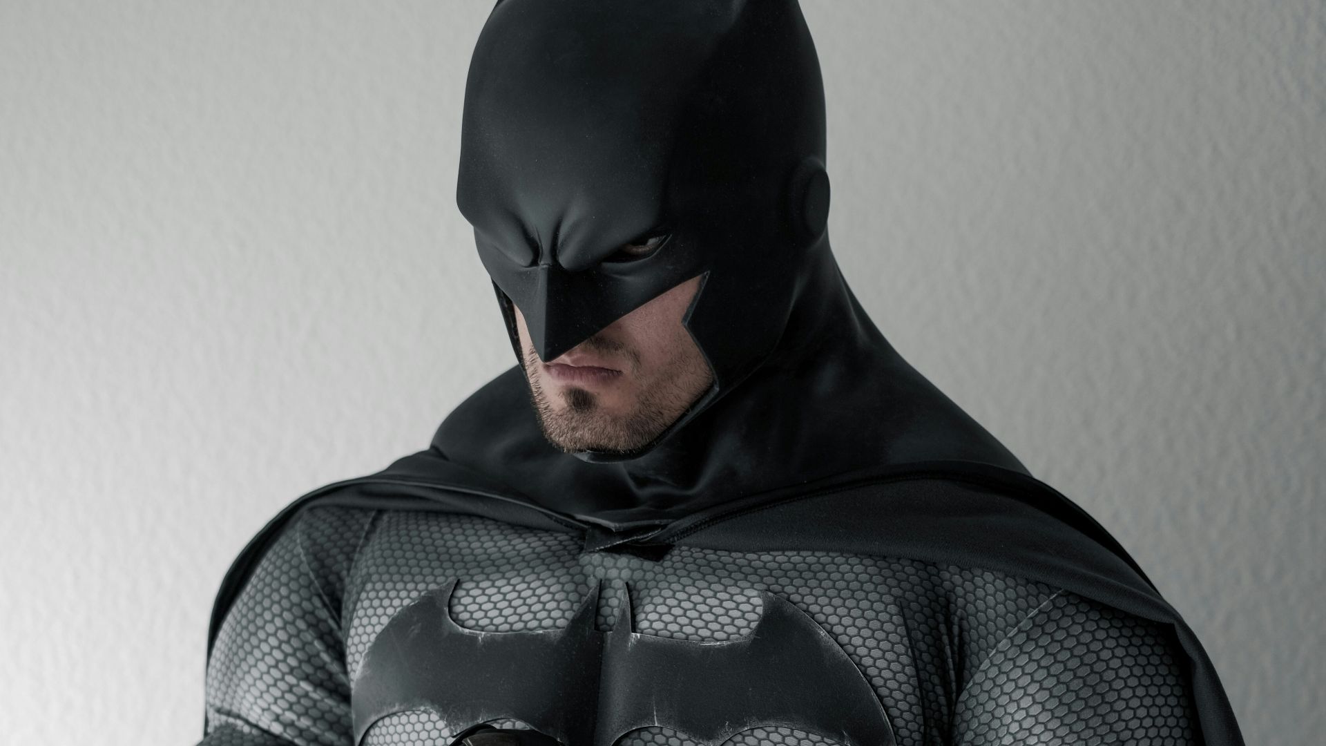 man in black and gray stripe hoodie sitting on brown wooden chair