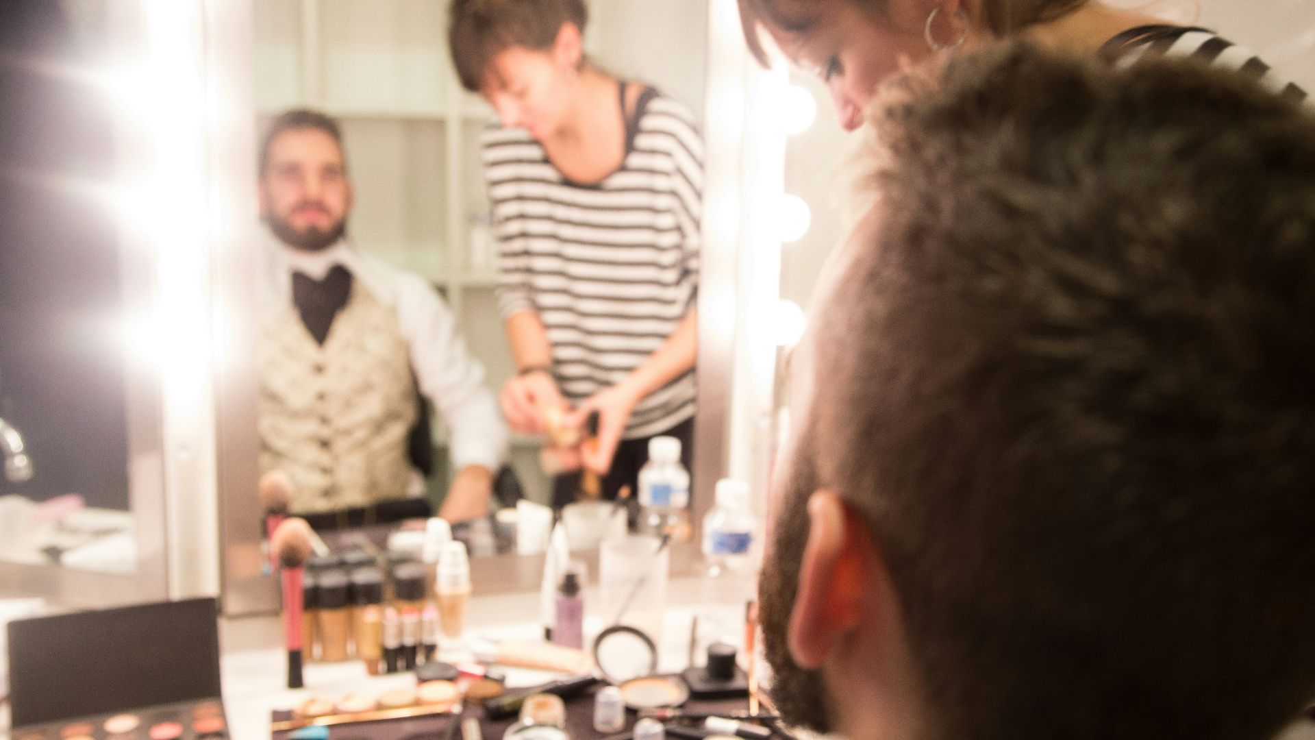 a group of people standing around a table with makeup