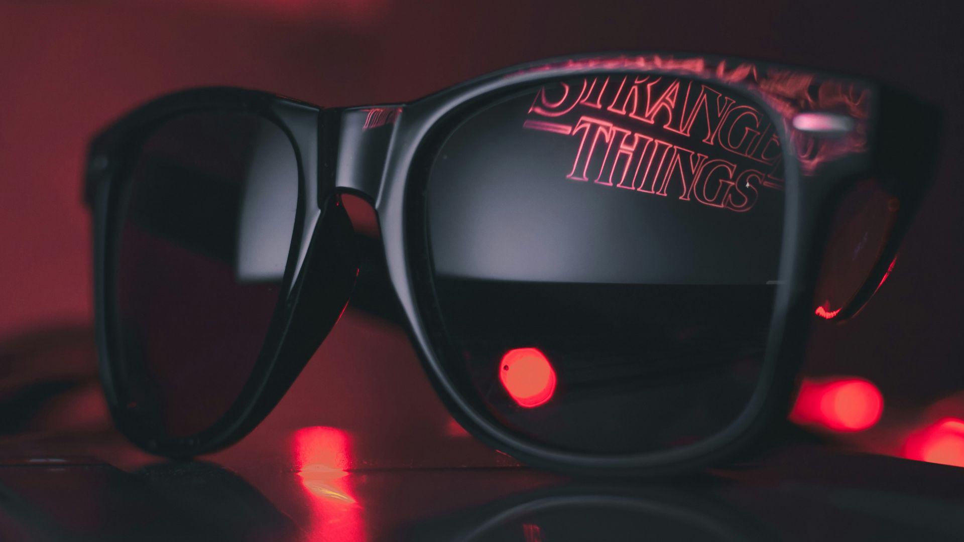 black wayfarer sunglasses on black surface