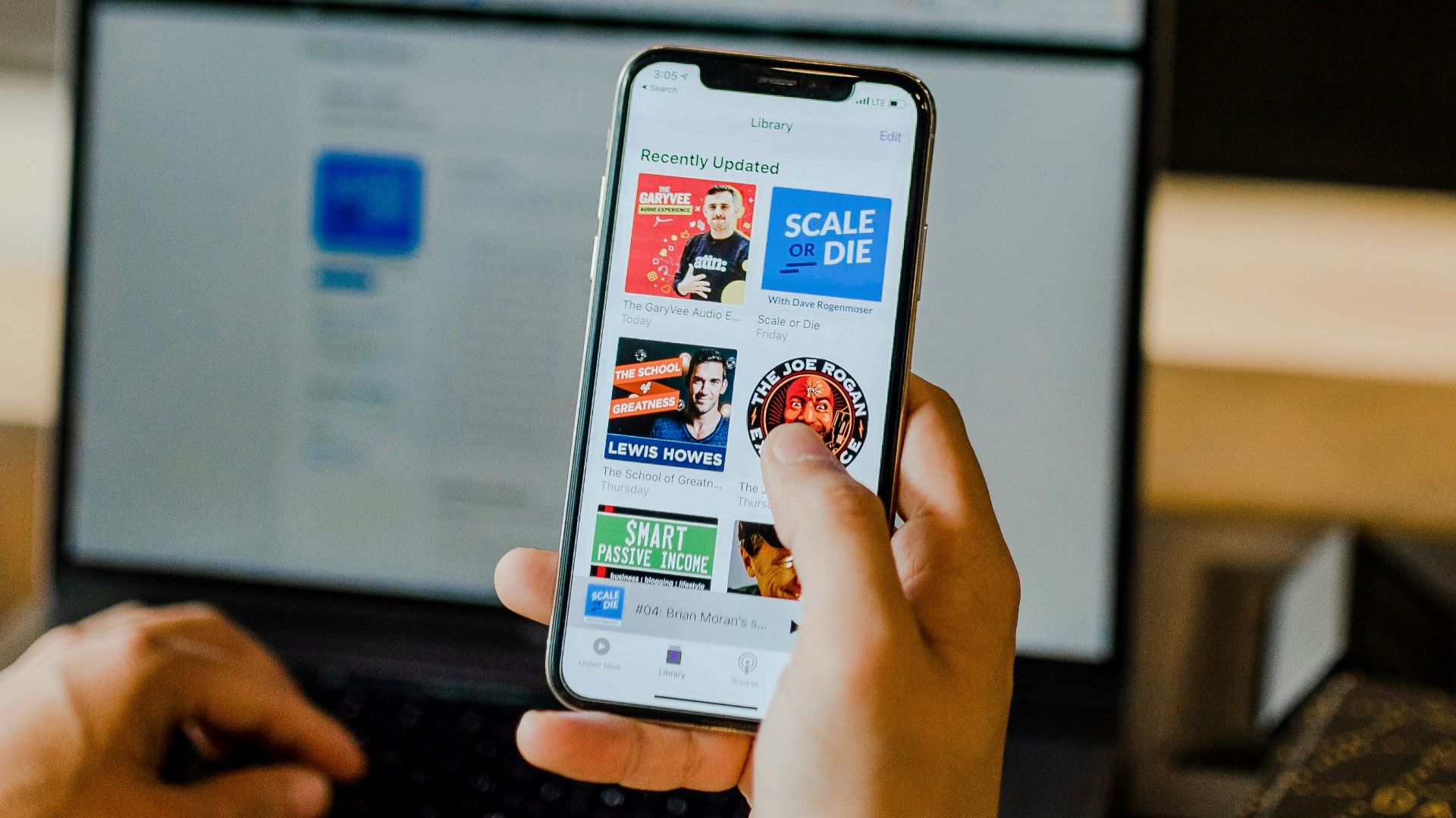 person using smartphone and laptop at the same time