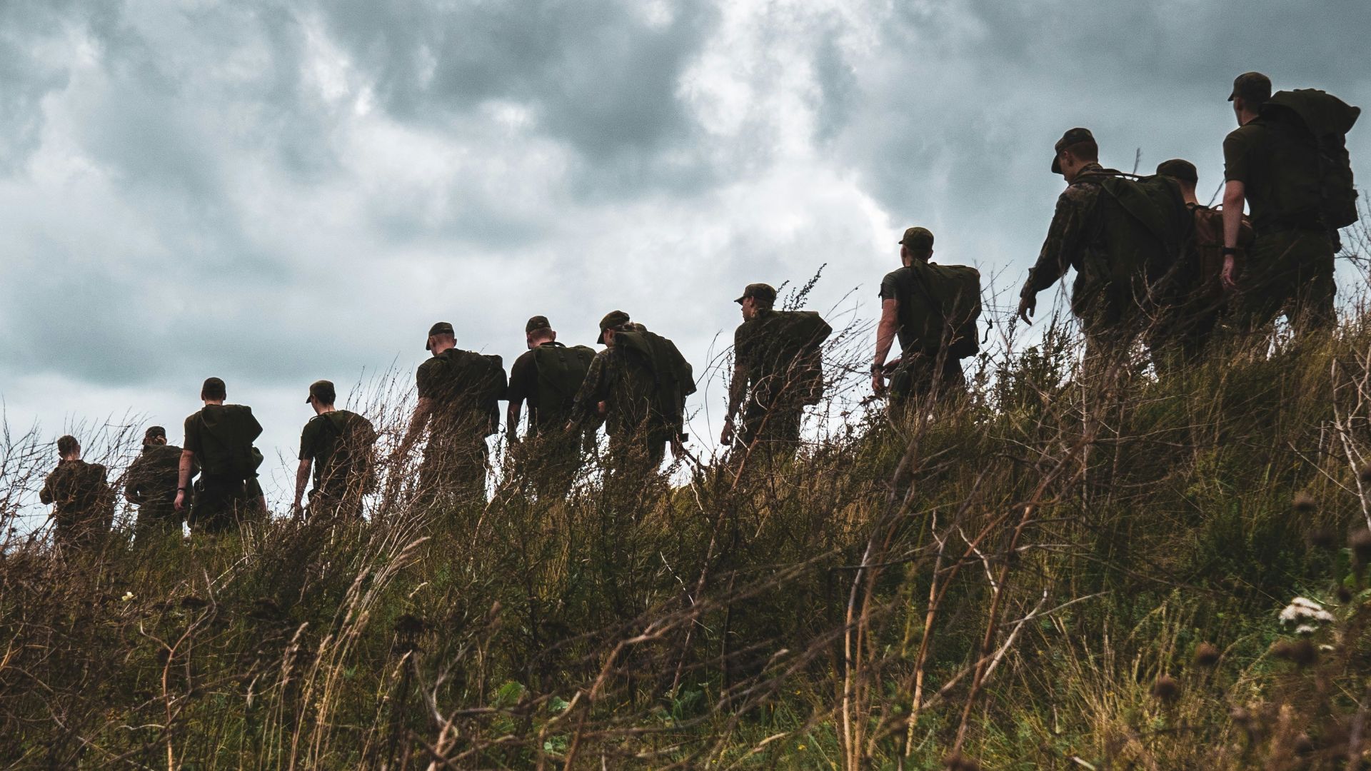 people standing on green grass field under cloudy sky during daytime