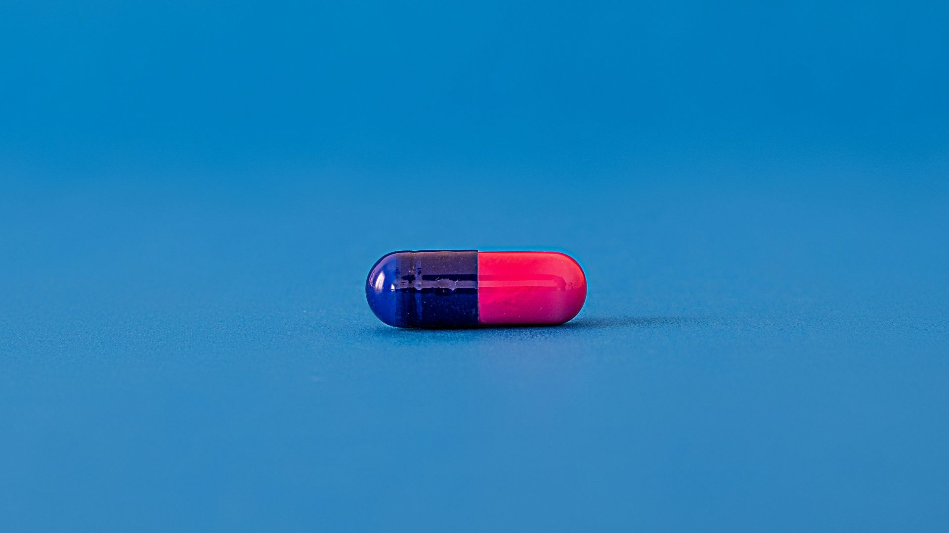 red and blue pill on blue surface