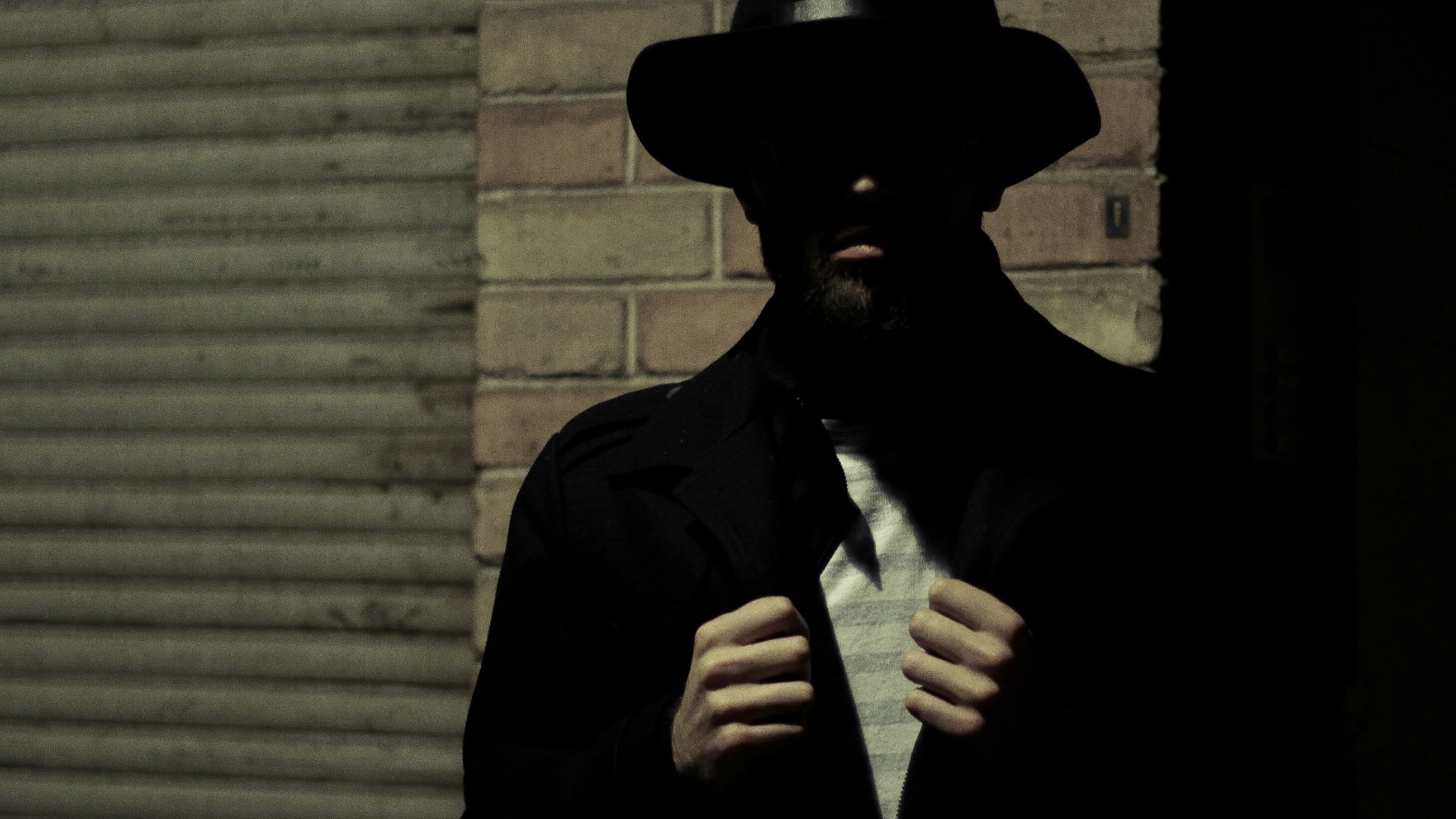 man wearing black fedora hat and black suit jacket