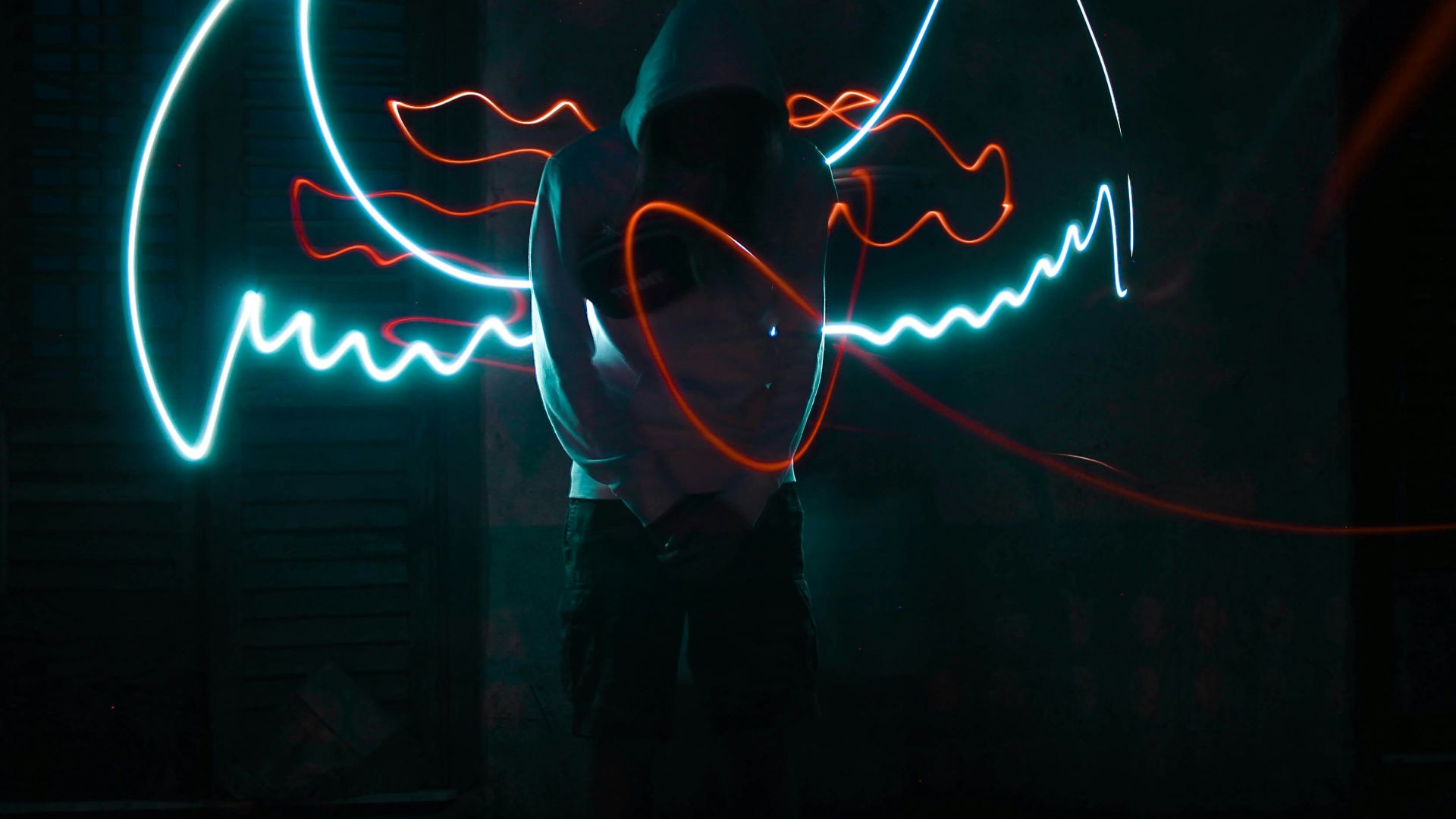 man in black jacket standing in front of neon light signage