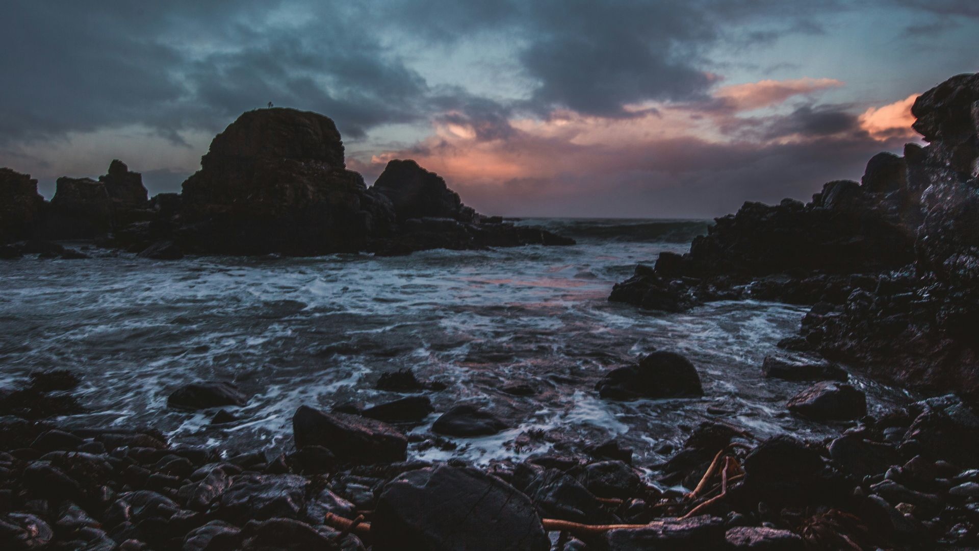 rocky body of water under gray sky