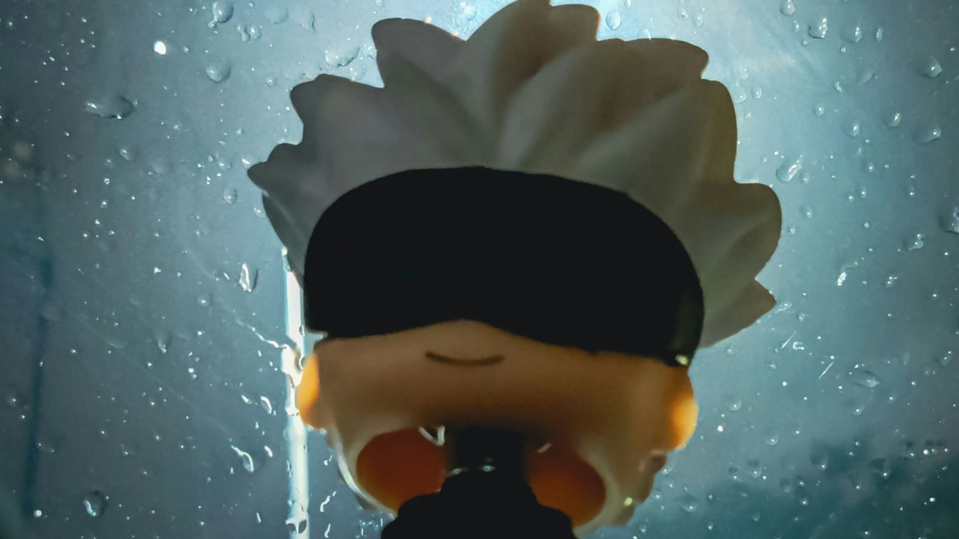 A person with a blindfolded head standing in front of a window