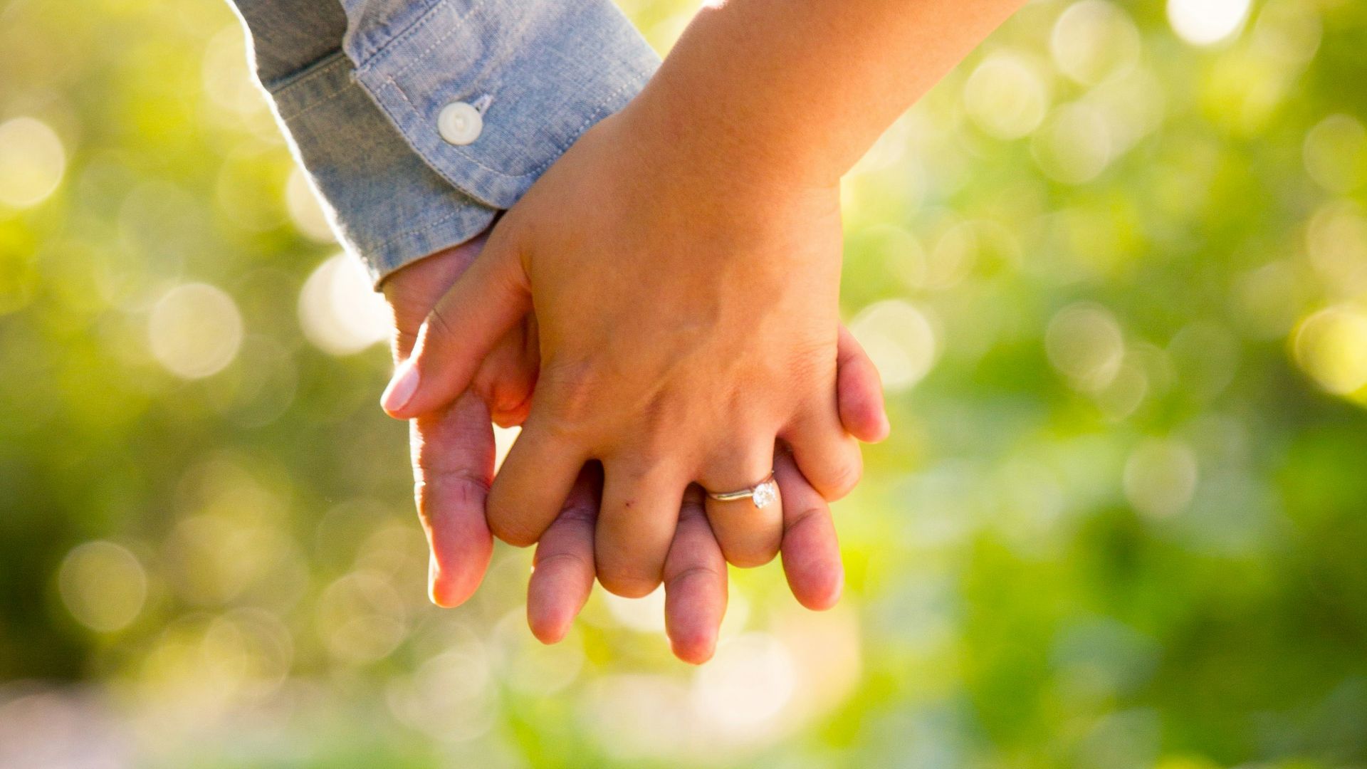 shallow focus photo of man and woman holding hands