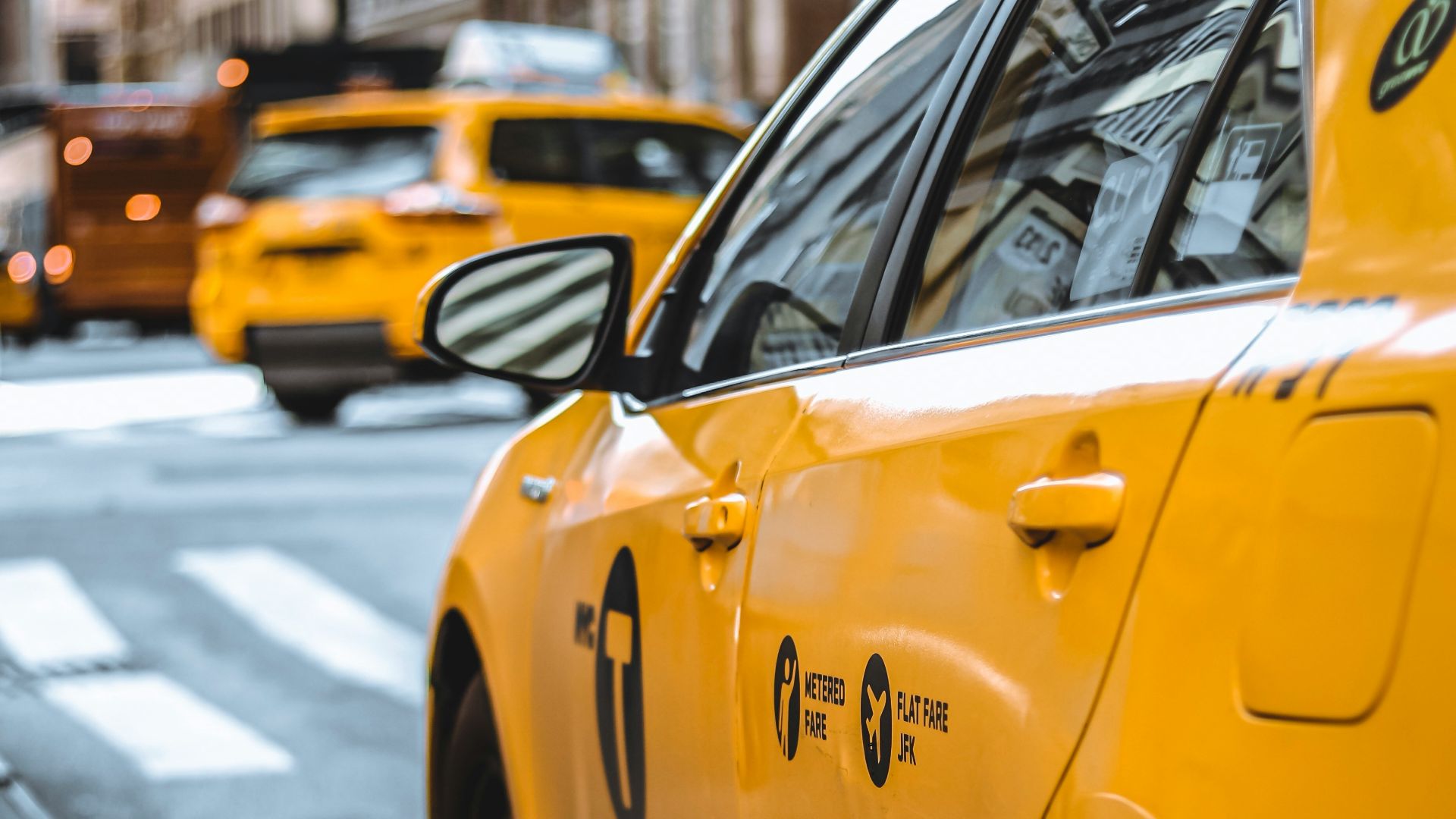 yellow taxi parked beside curb