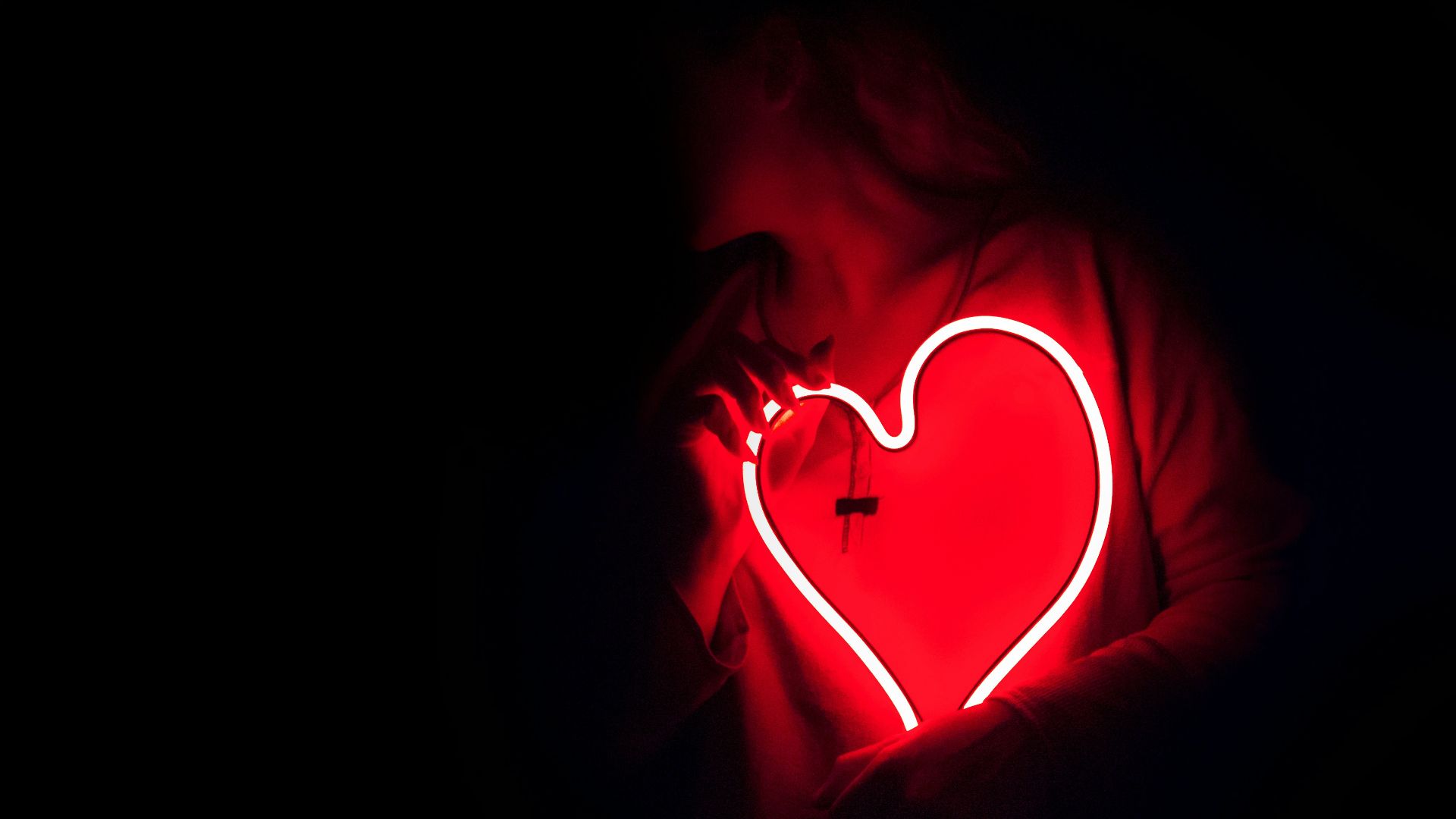 a heart shaped neon sign in the dark