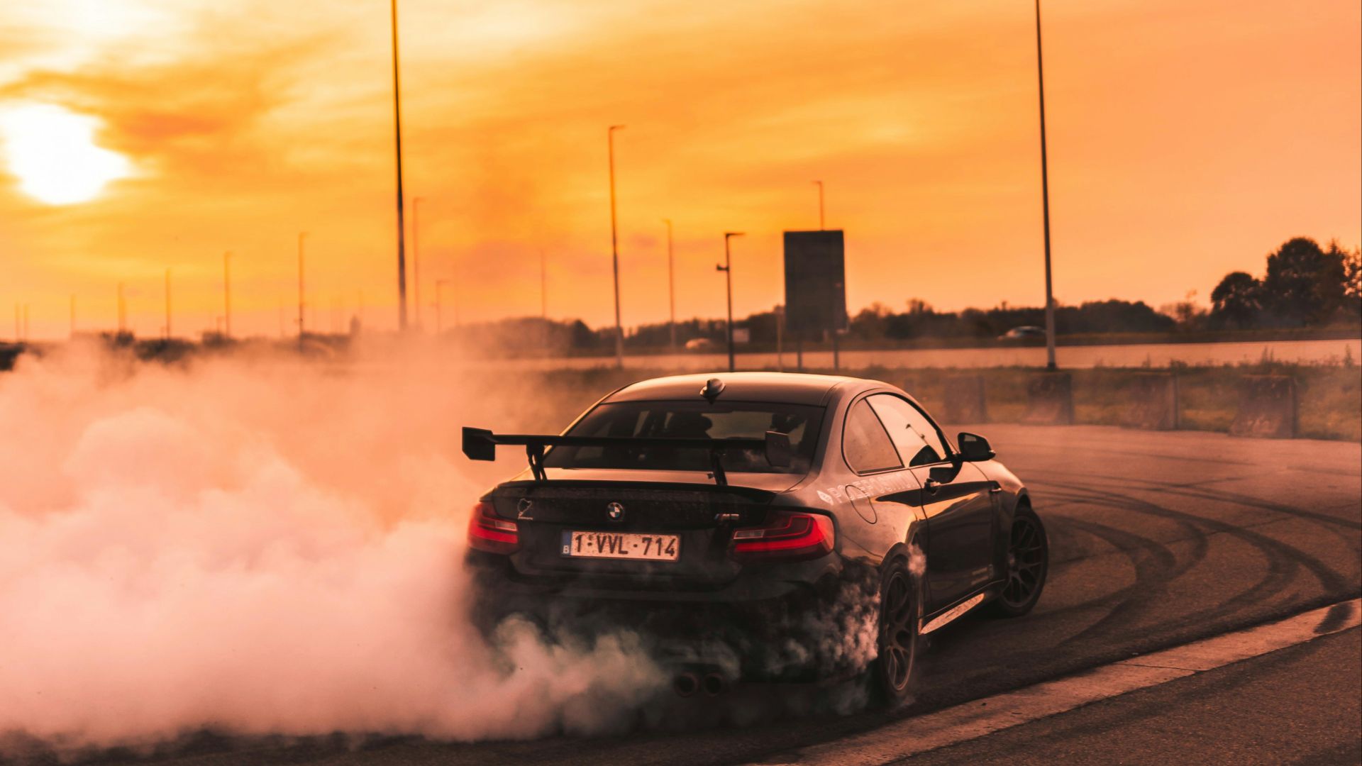 black car drifting on road during day