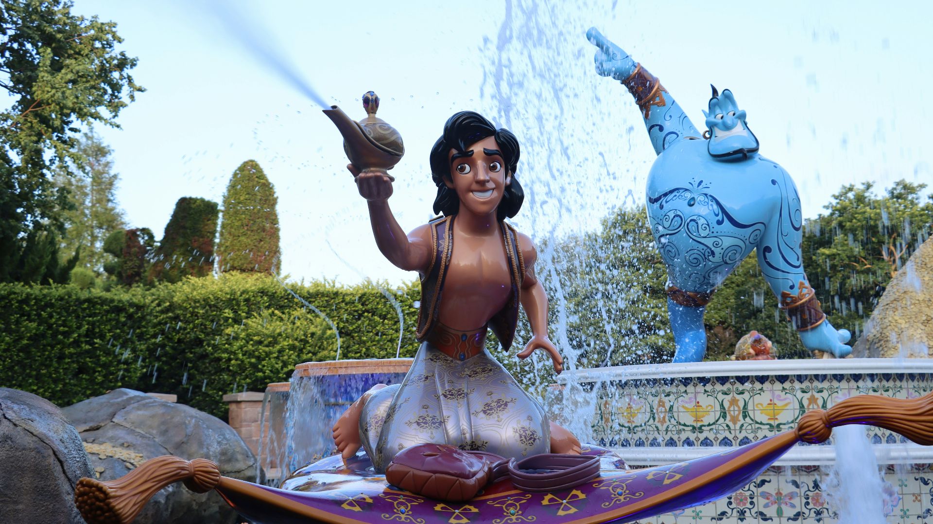 a woman sitting on a fountain with a statue of a man holding a sword
