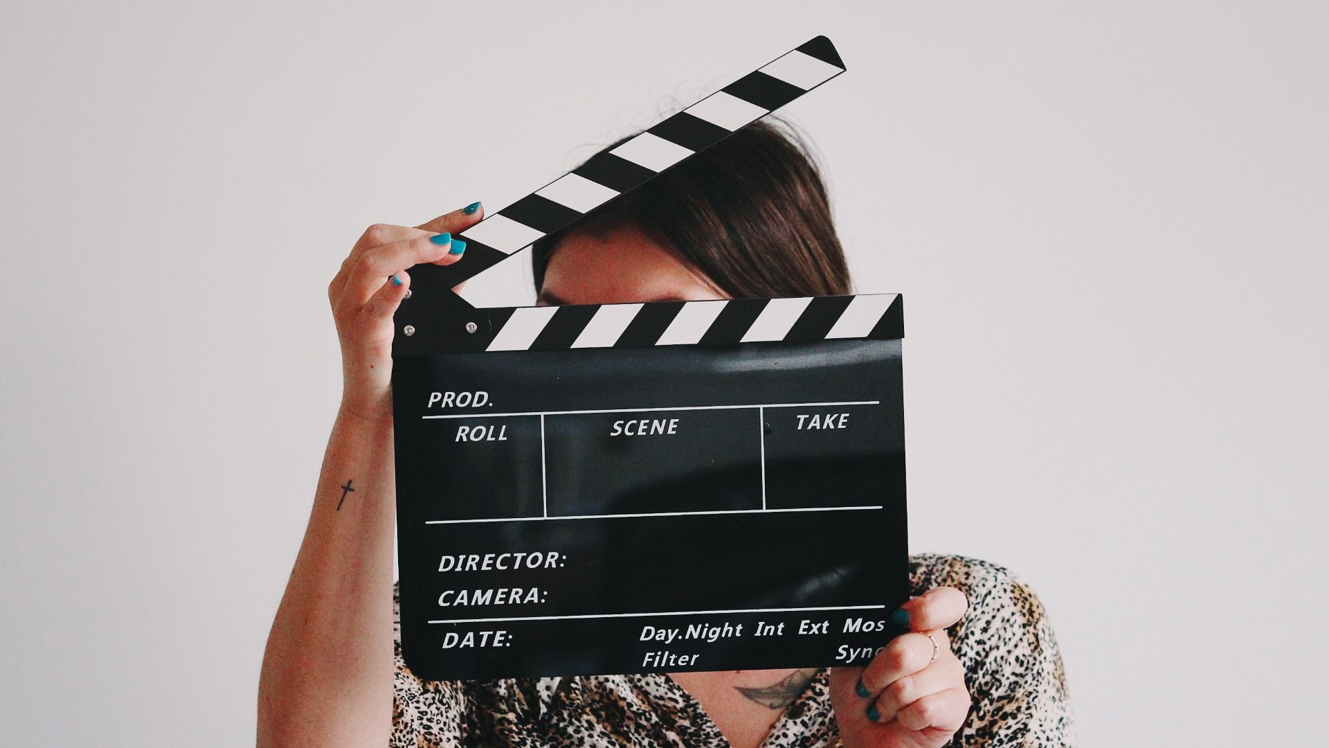 a woman holding a clapper over her face