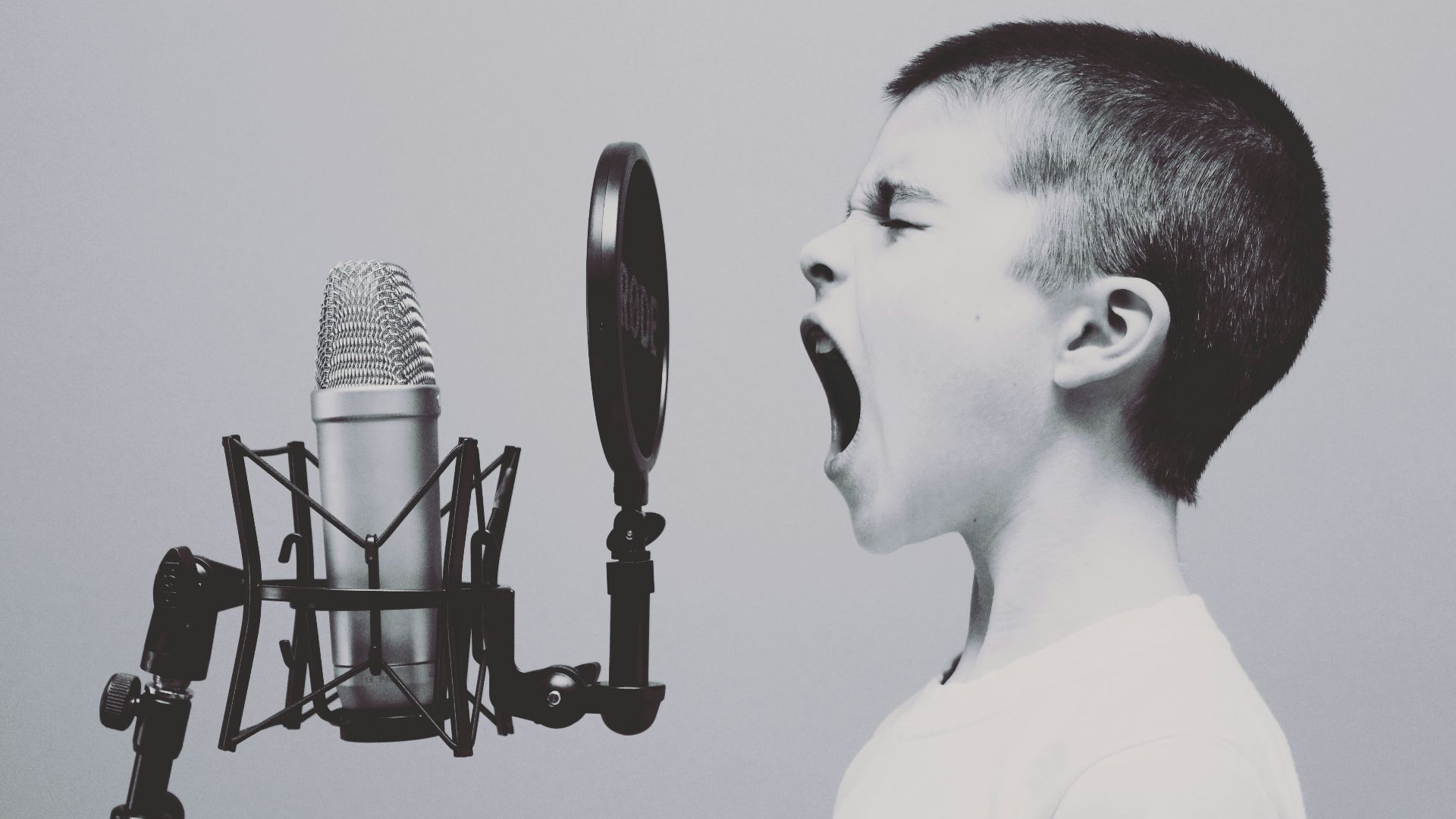 boy singing on microphone with pop filter