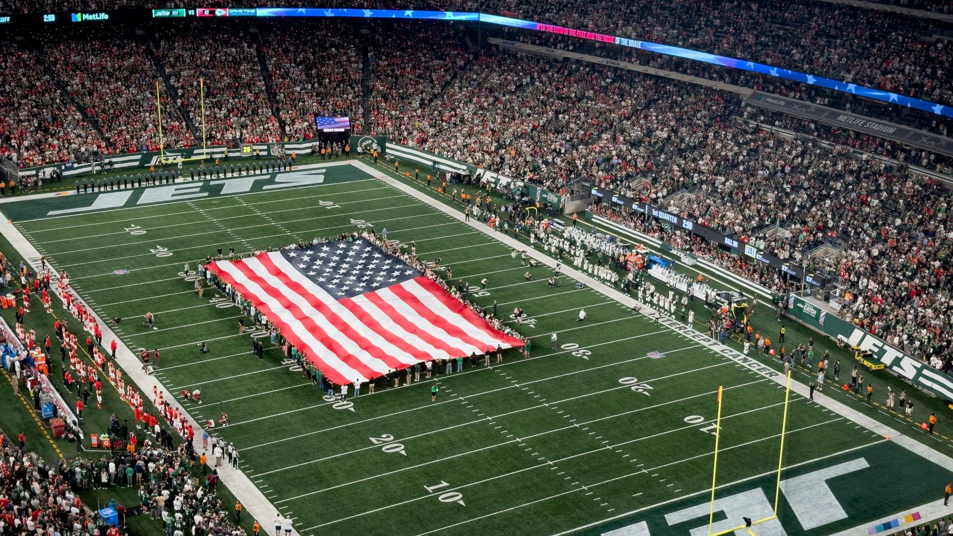 a football field with a large american flag on it