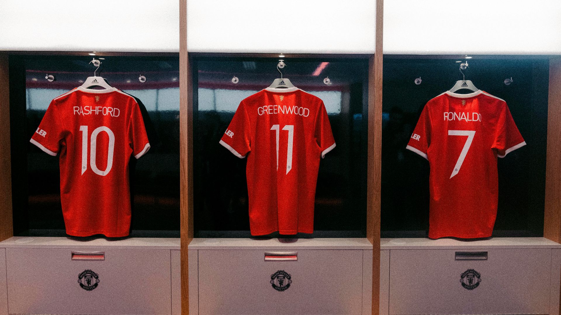 a display case with three red soccer jerseys