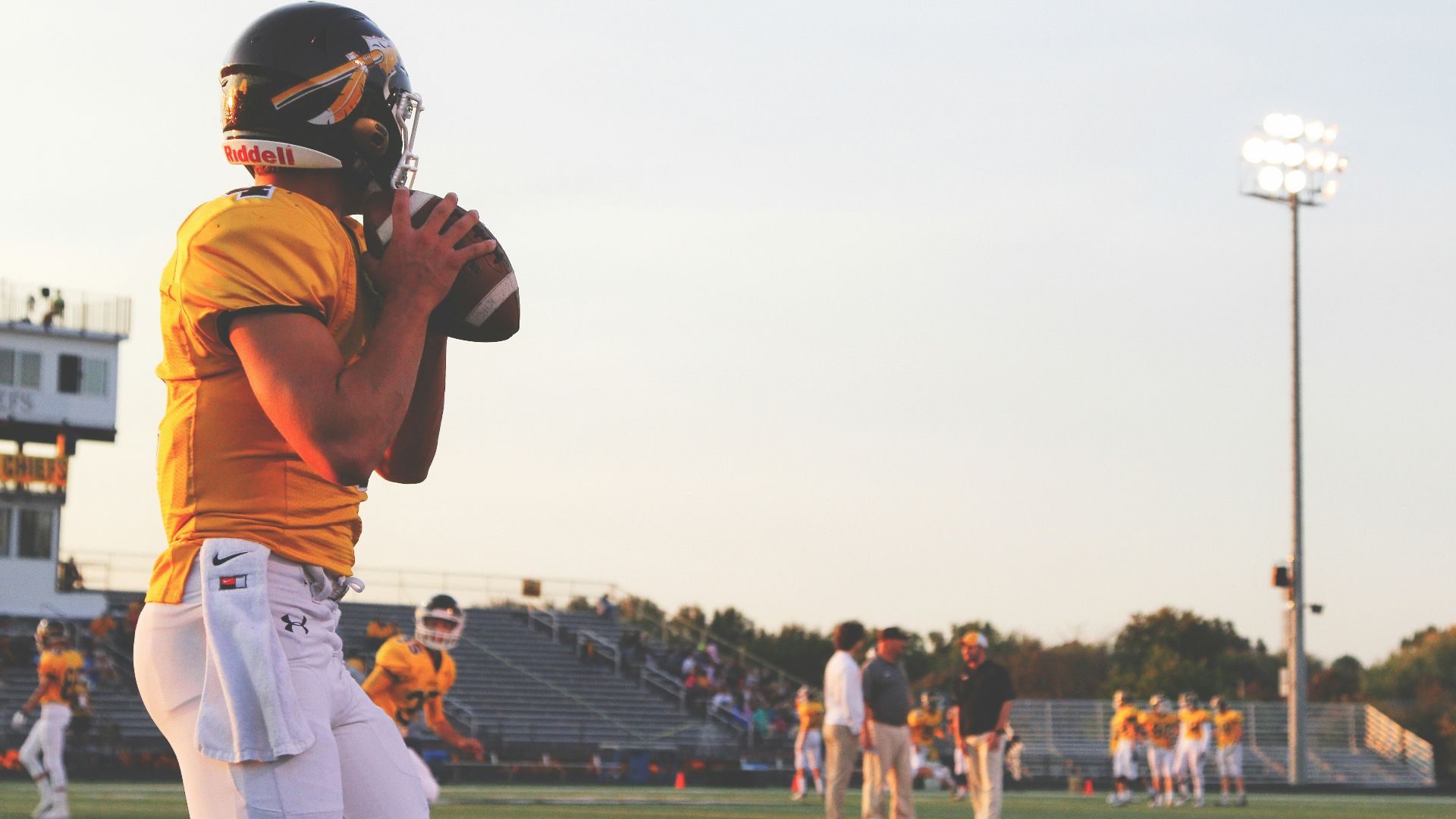 man holding brown football ball