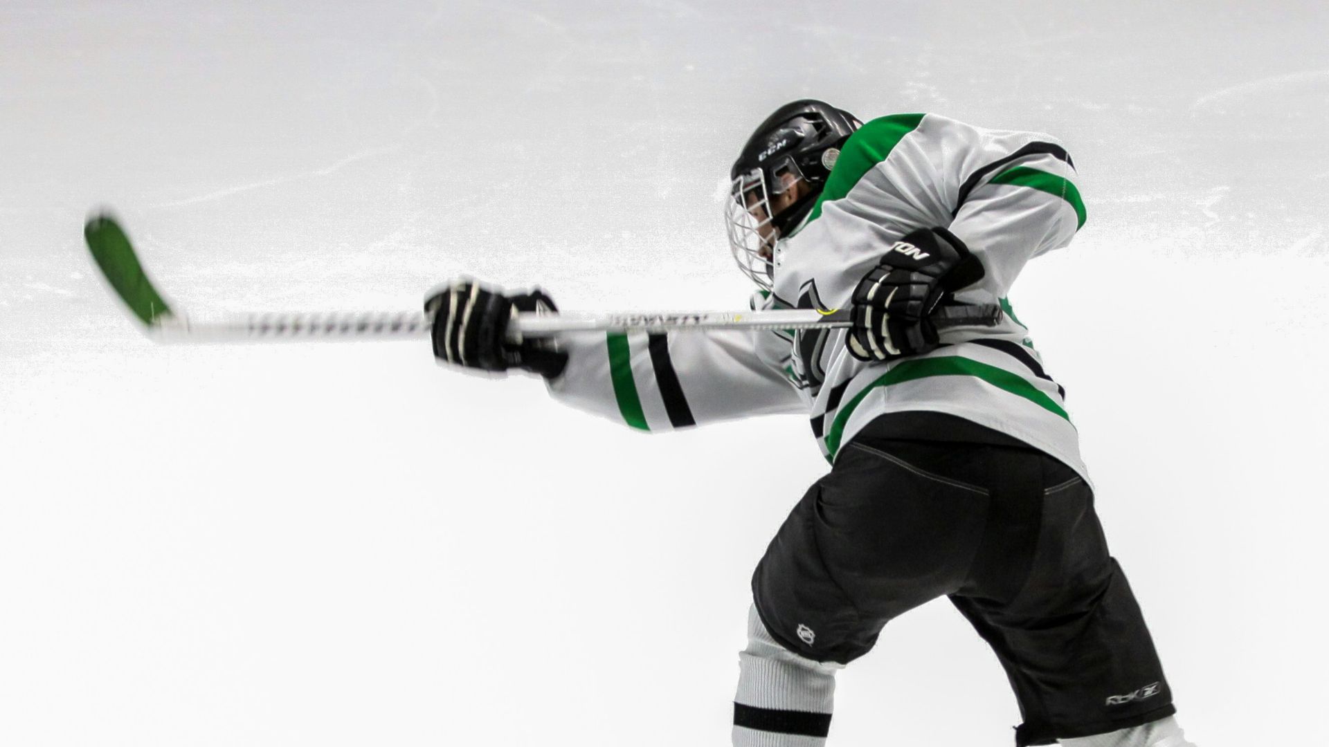 man wearing green and white ice hockey jersey while playing