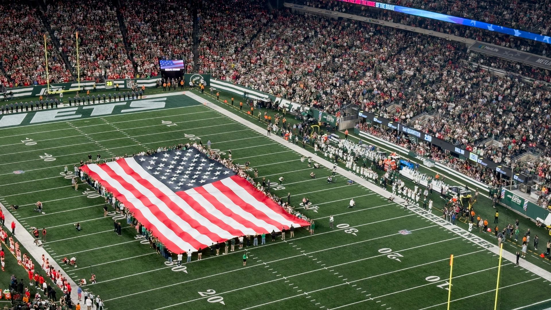 a football field with a large american flag on it