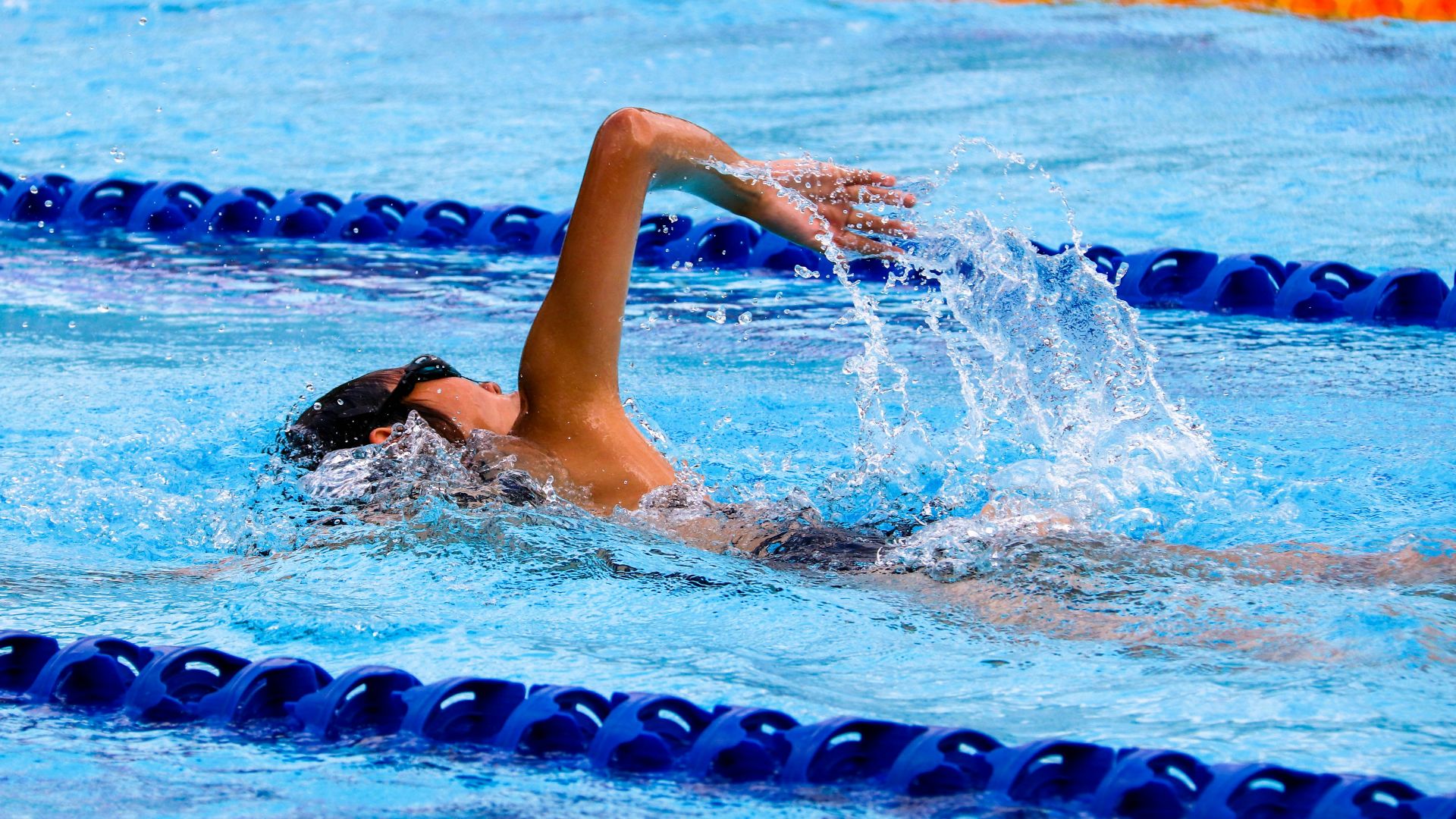 person swimming on an olympic pool