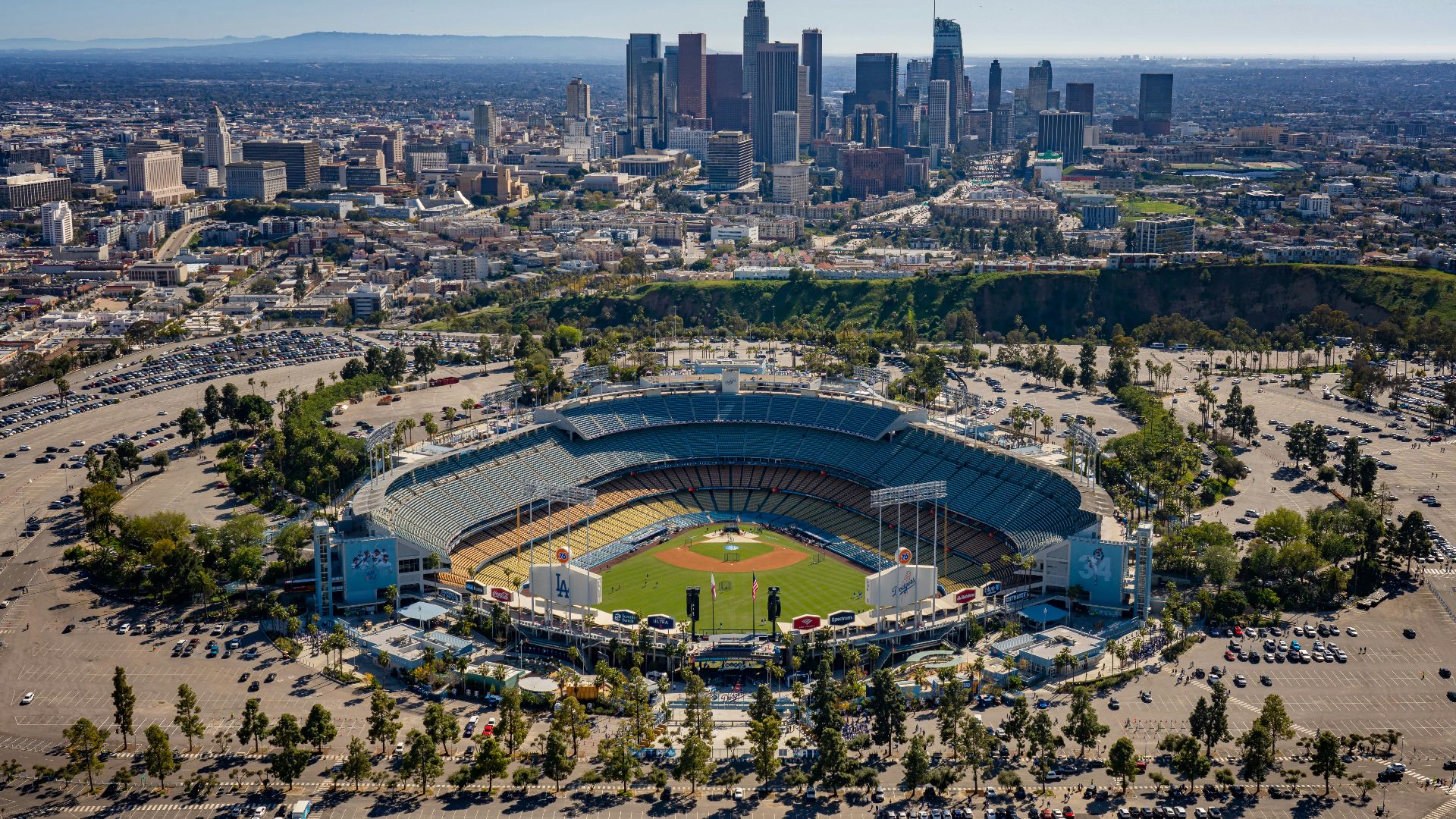 an aerial view of a baseball stadium with a city in the background