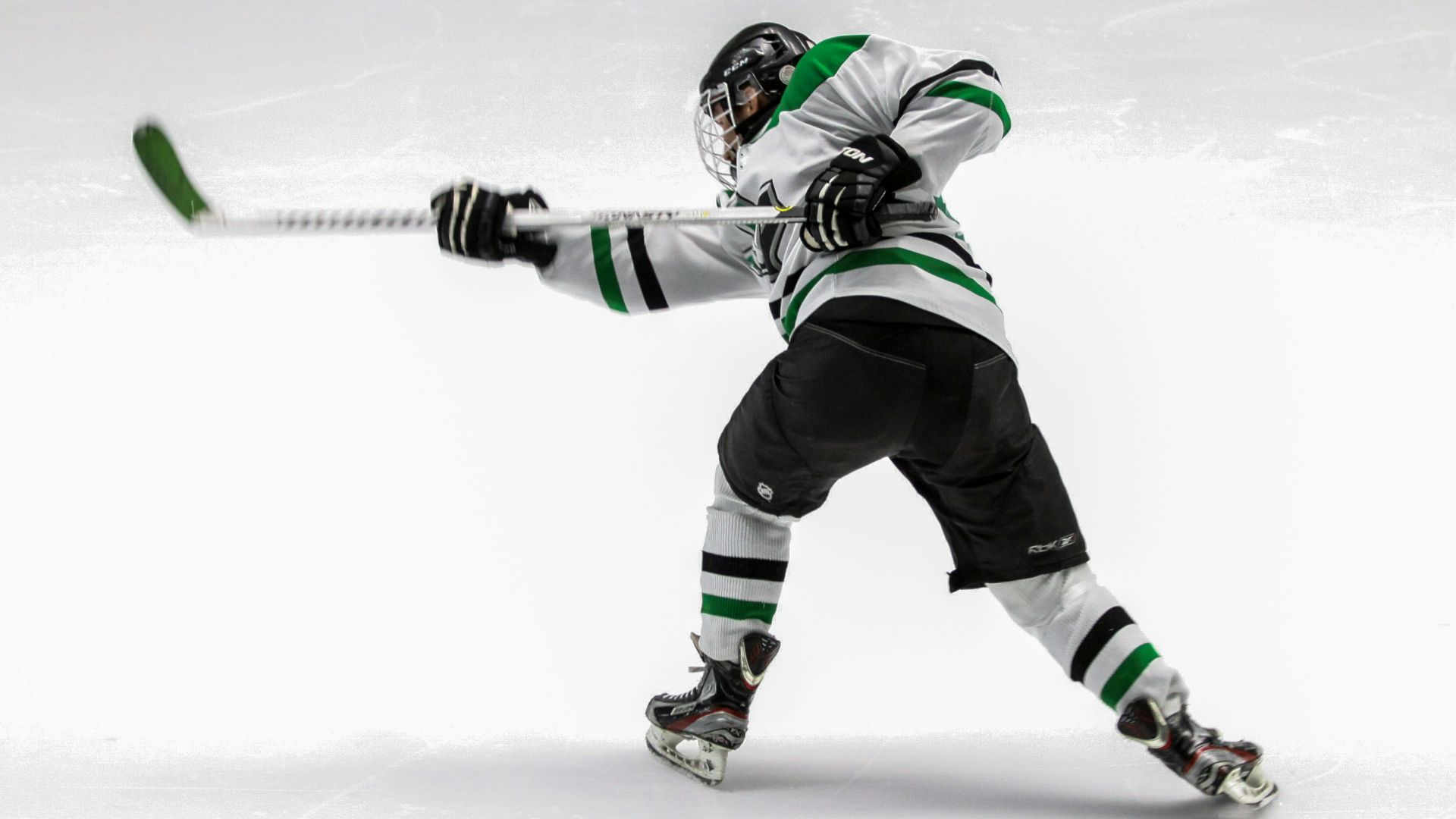 man wearing green and white ice hockey jersey while playing