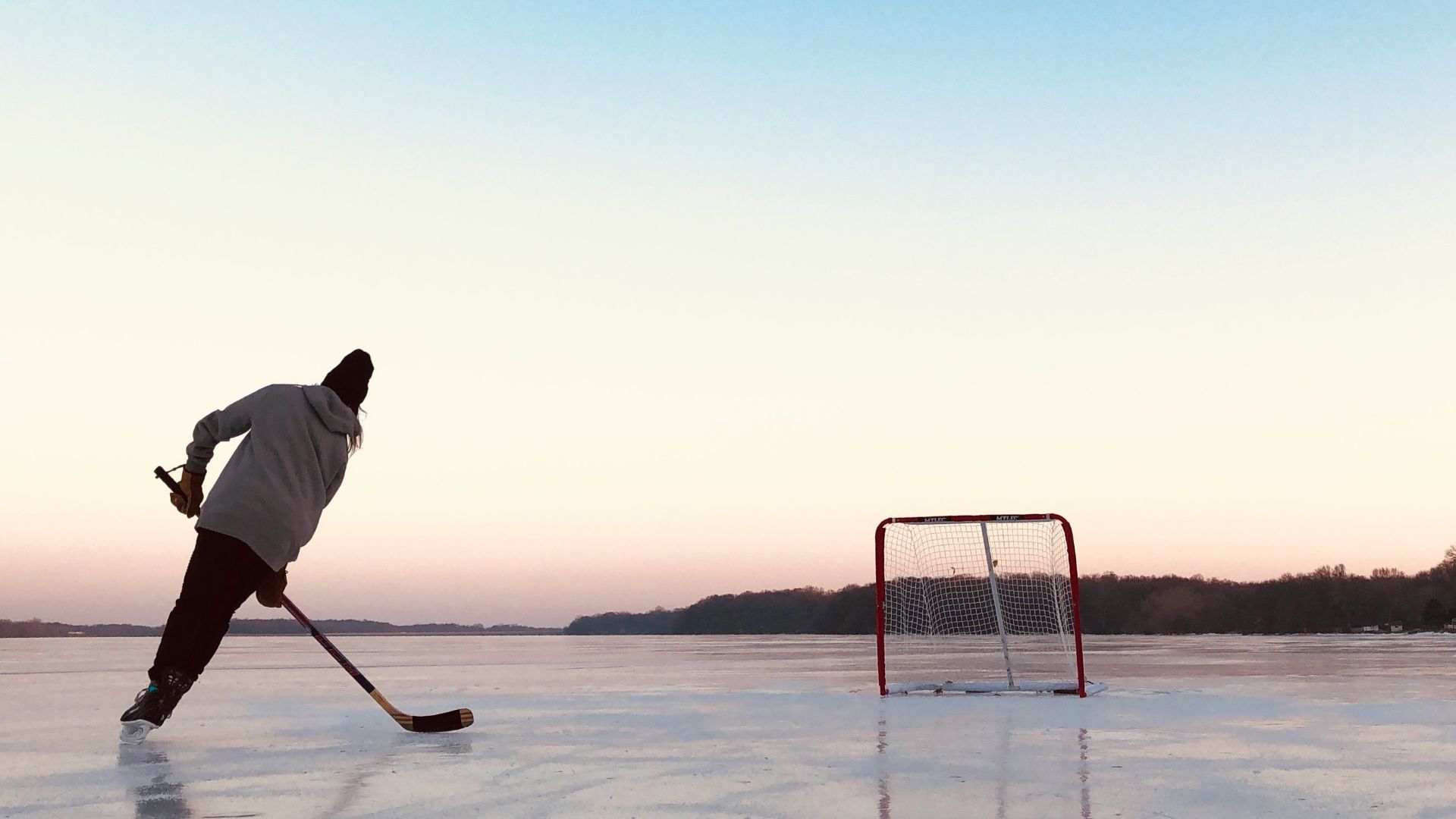 man in white shirt and black pants holding white stick standing on snow covered ground during