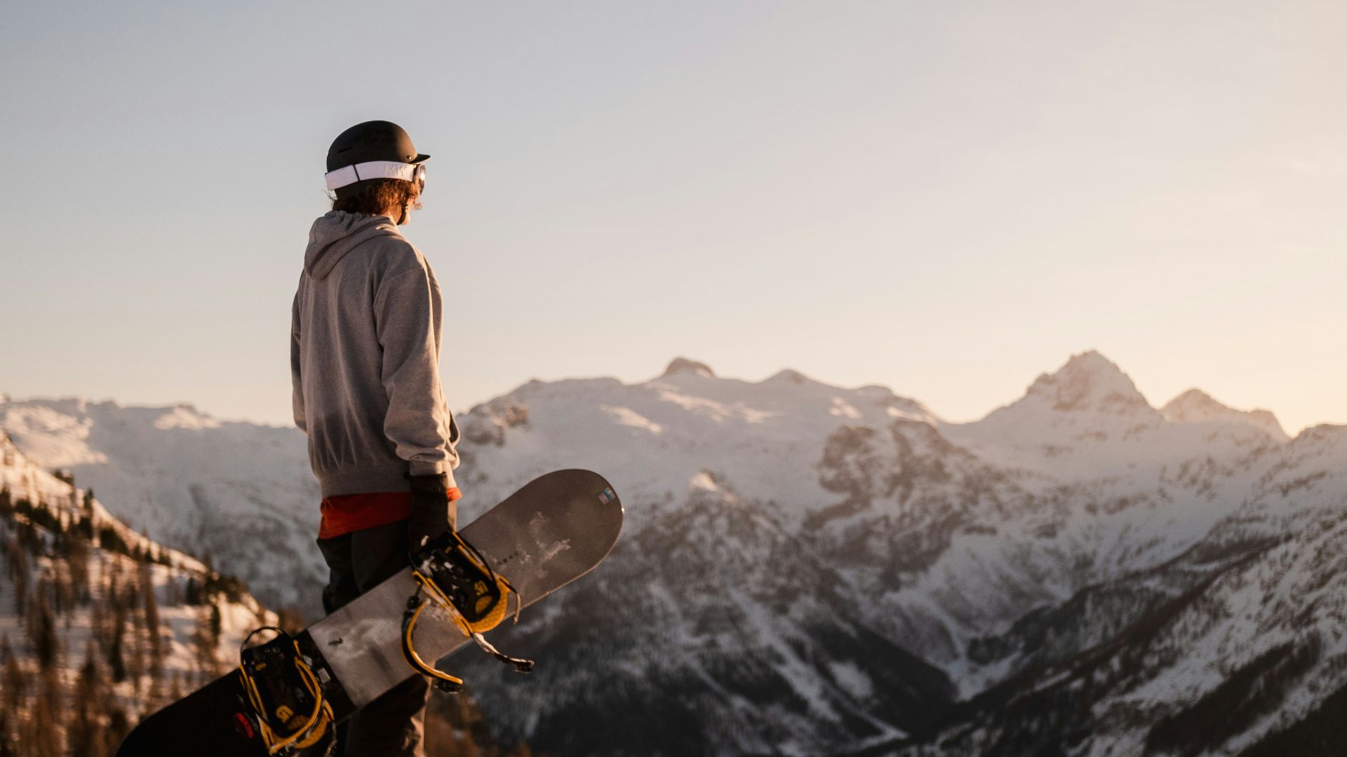 man in white jacket and black pants standing on brown rock formation during daytime