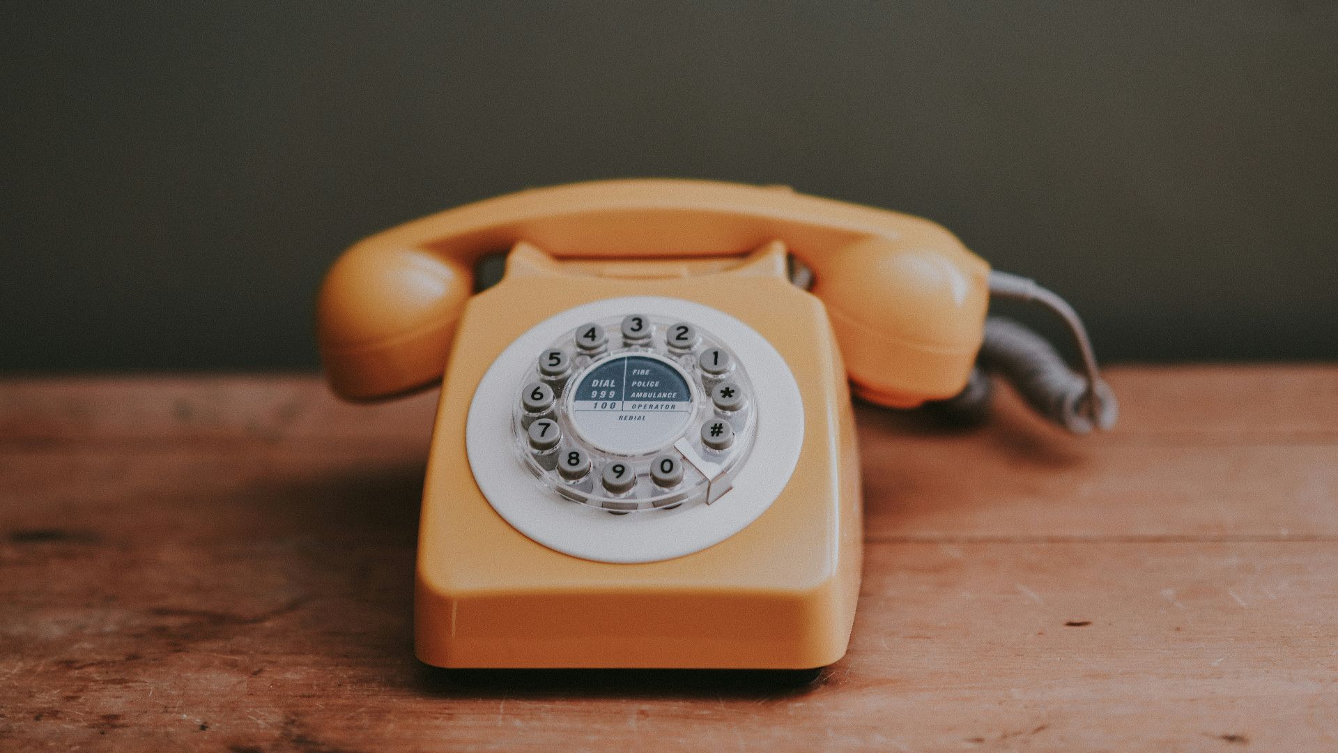 brown rotary dial telephone in gray painted room
