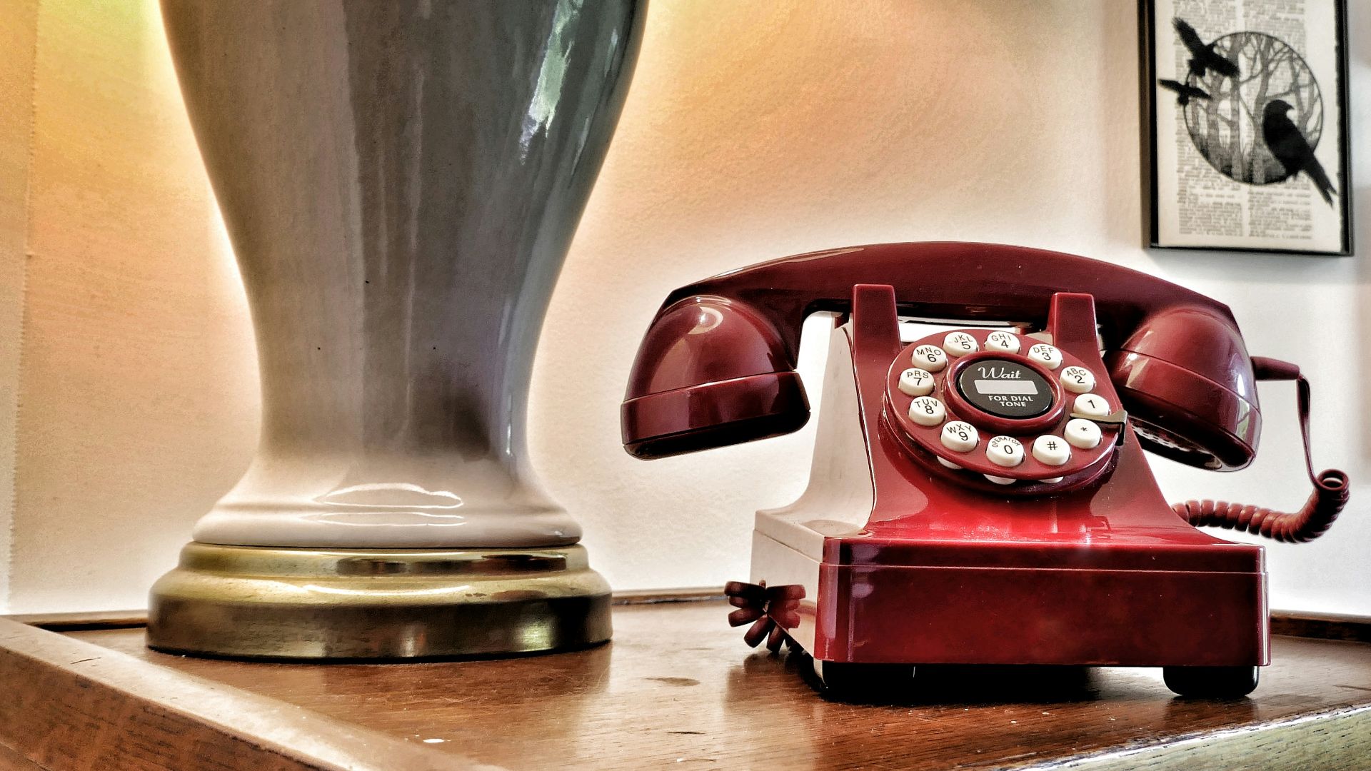 Vintage red rotary phone on wooden surface