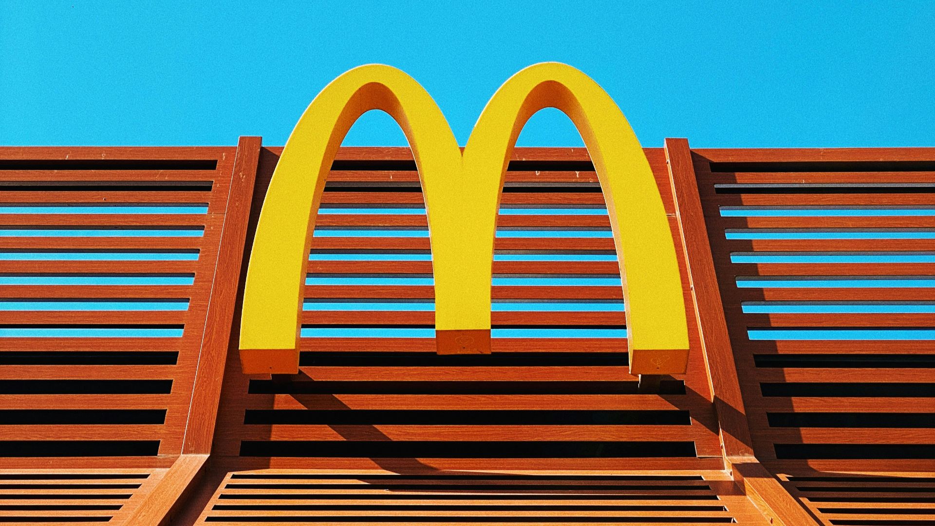 a wooden bench with a mcdonald's logo on it