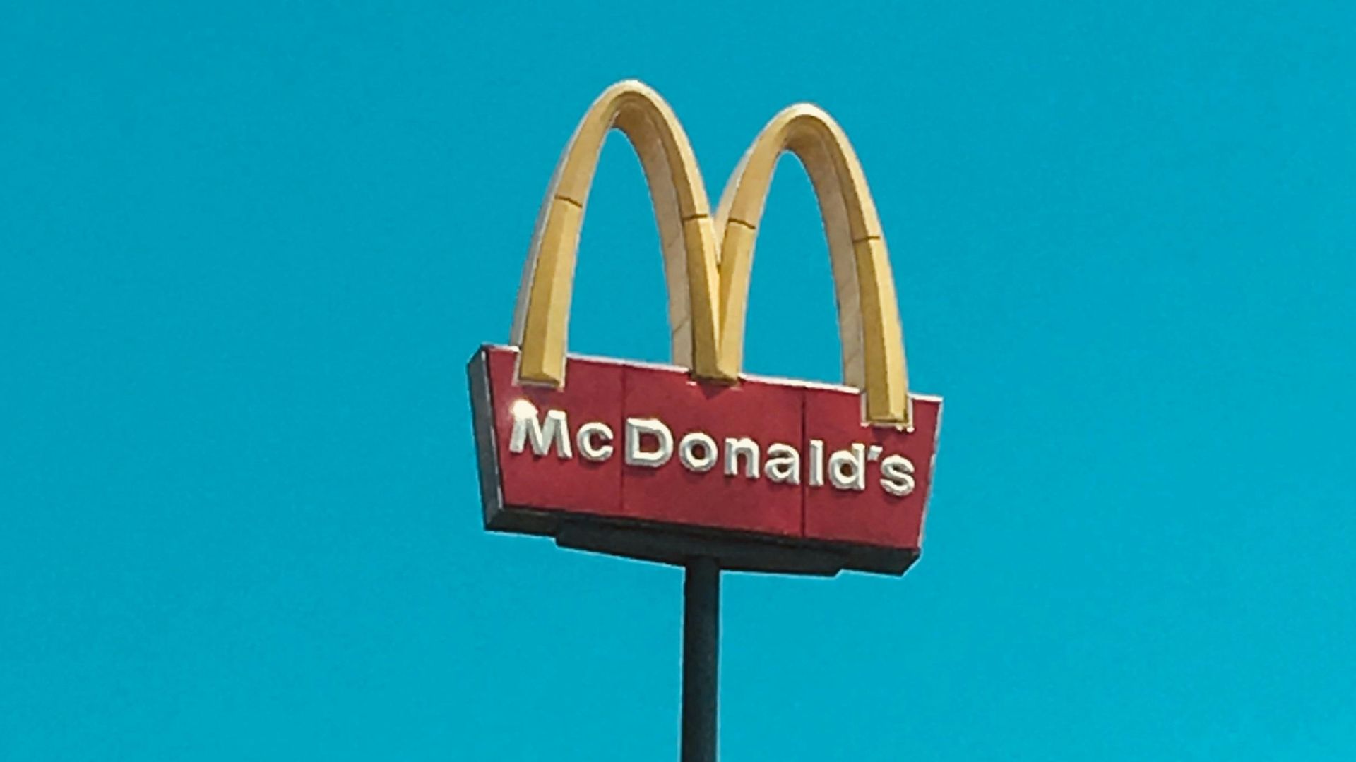 a mcdonald's restaurant sign in front of a blue sky
