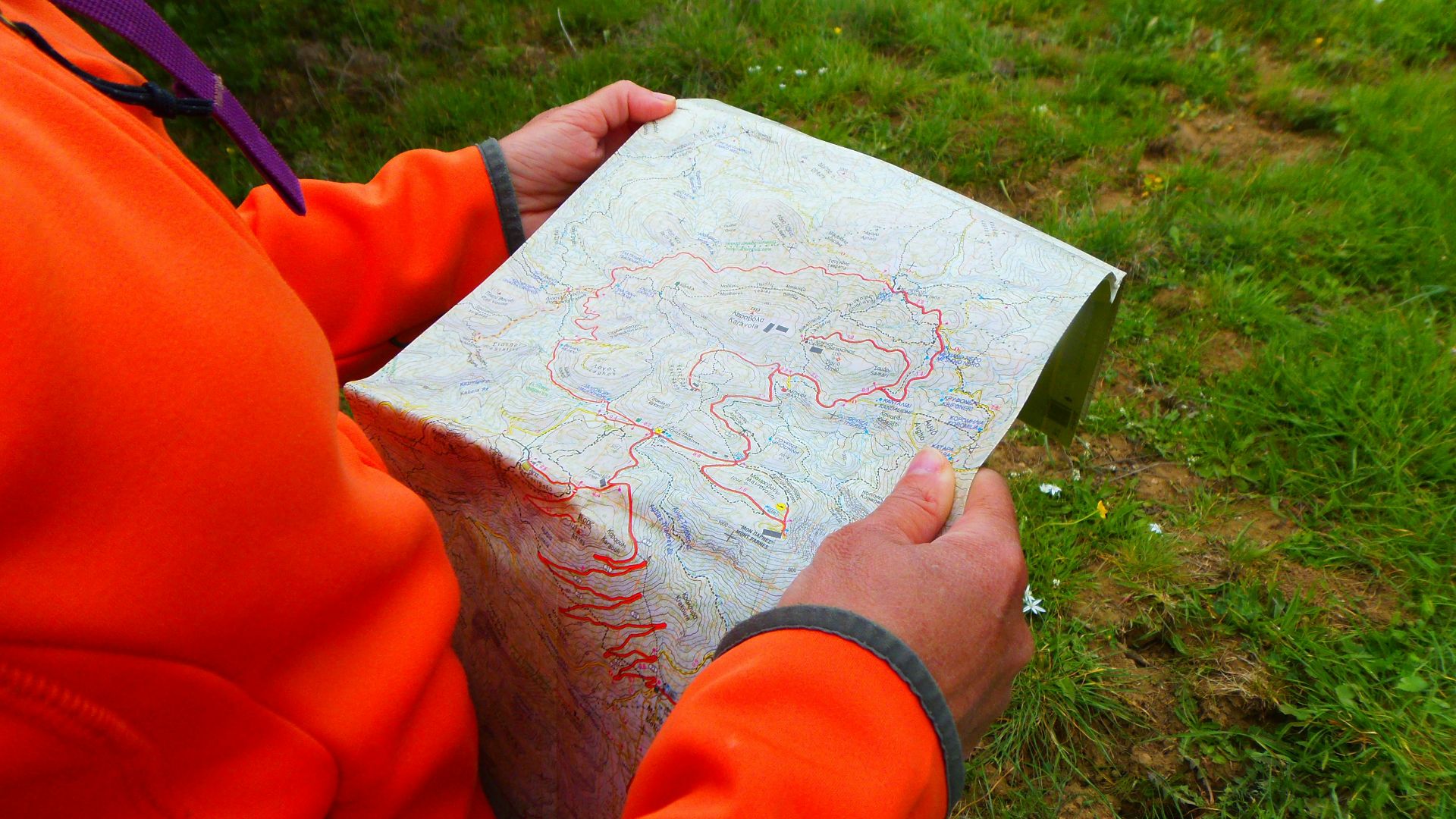 person in orange long sleeve shirt holding white printer paper