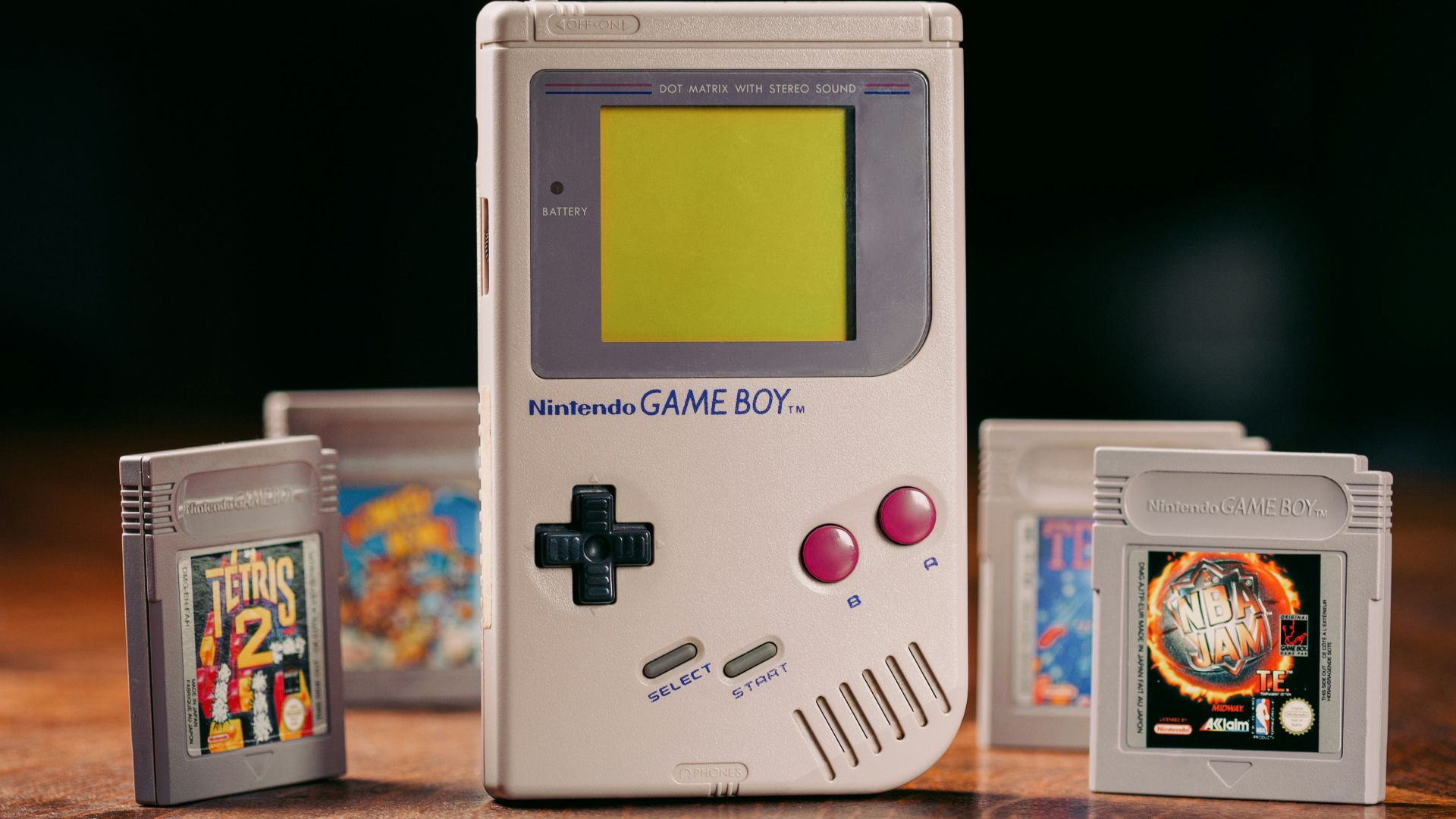 a nintendo game boy sitting on top of a wooden table