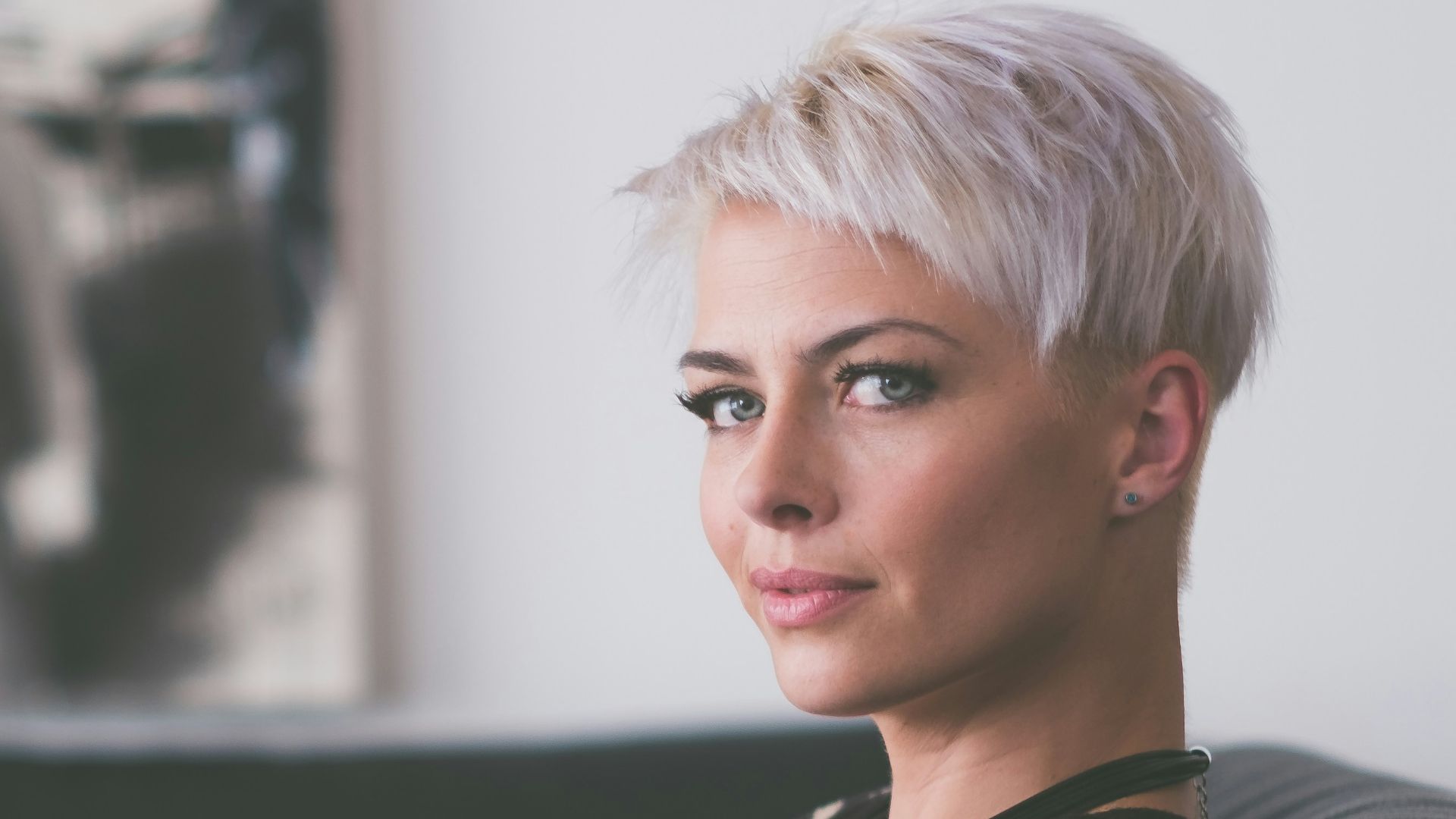 woman sitting on sofa holding eyeglasses