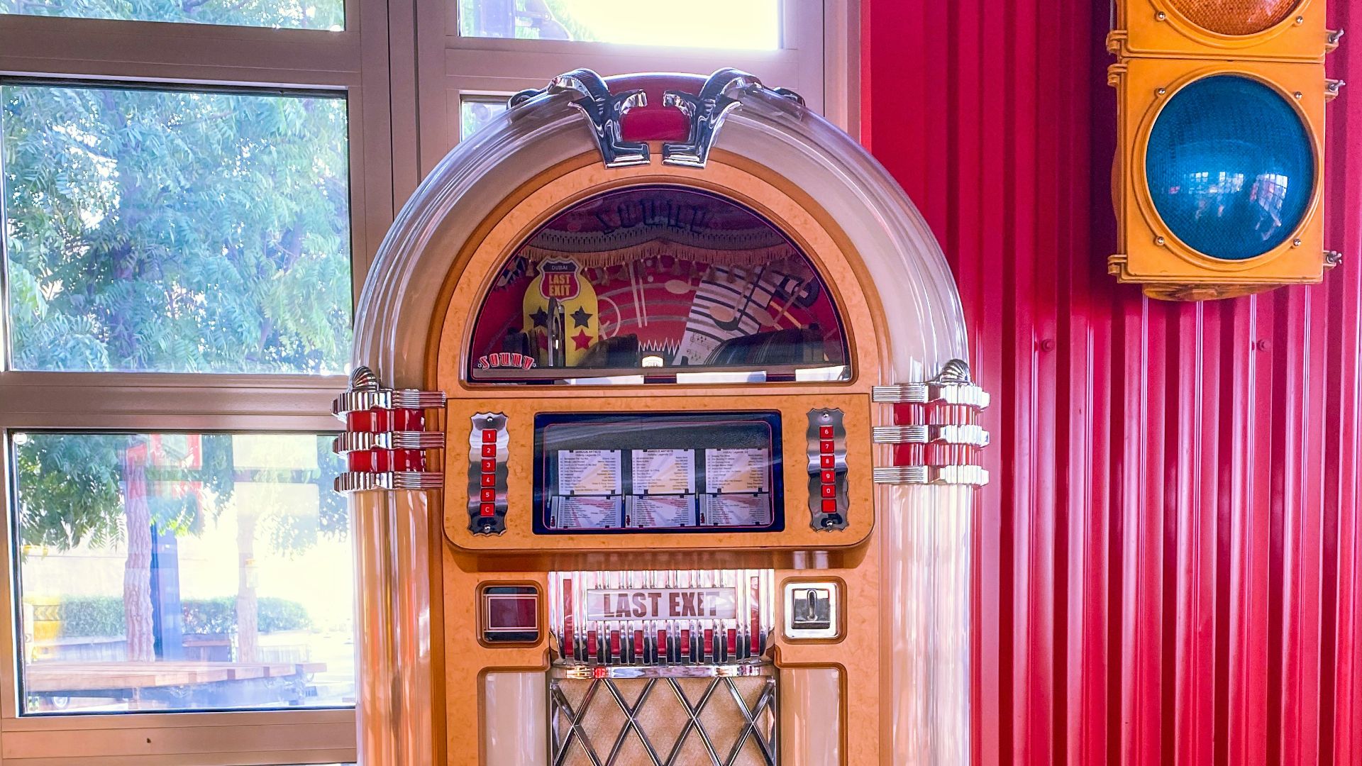 a jukebox sitting in front of a window next to a traffic light