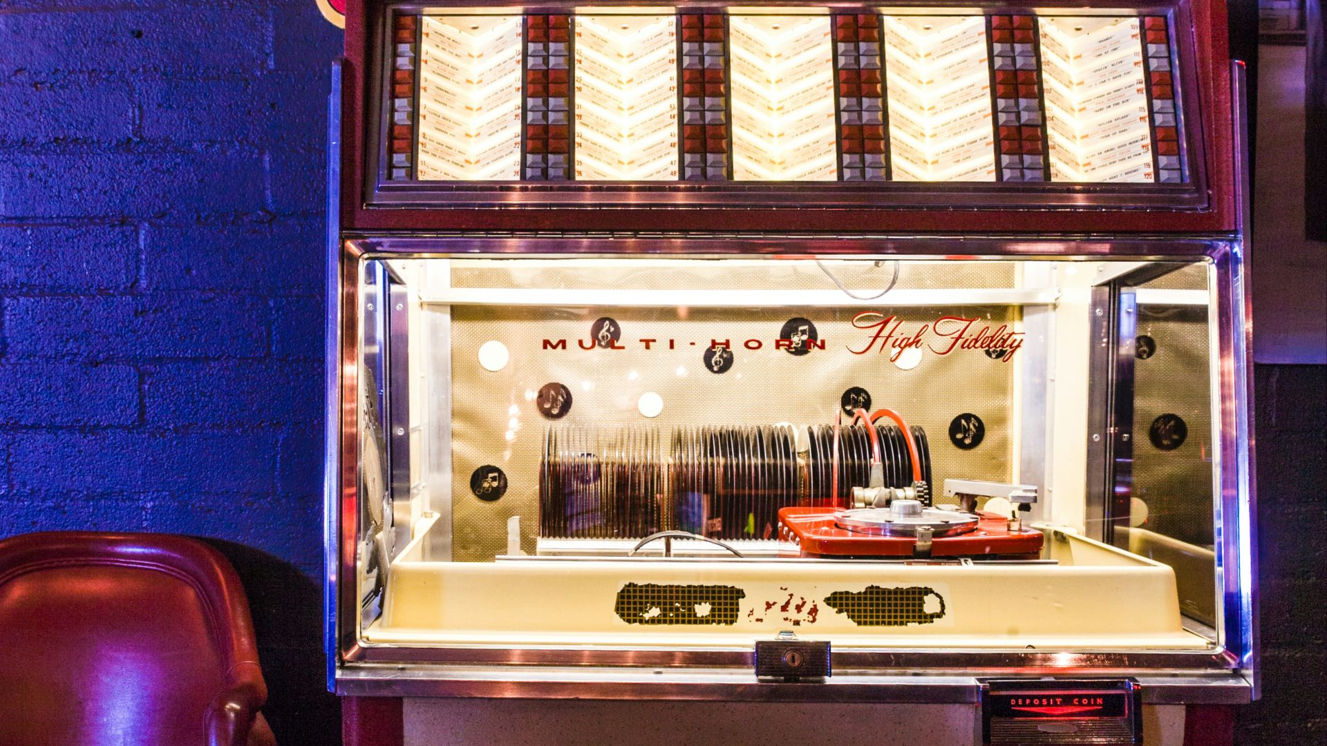 lighted brown and white arcade game console near wall