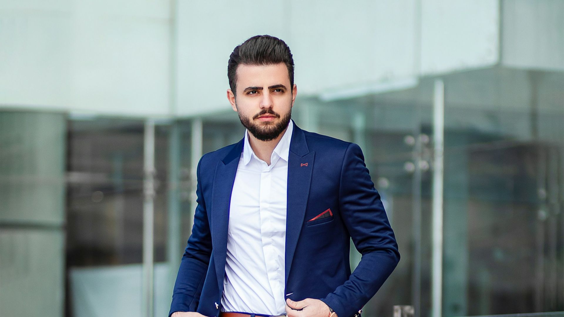 man in blue suit standing on sidewalk during daytime