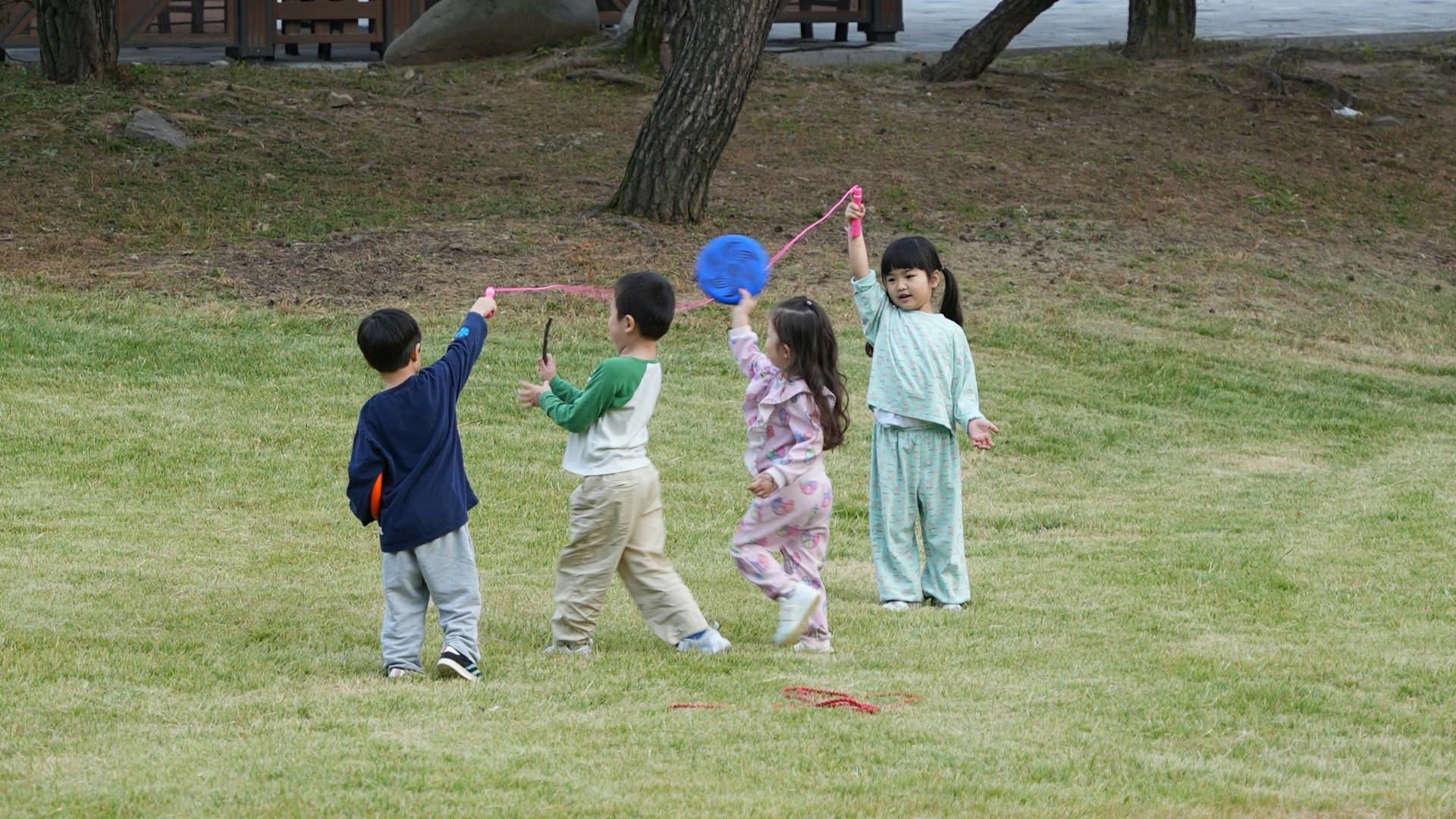 Children playing with kites in a grassy park