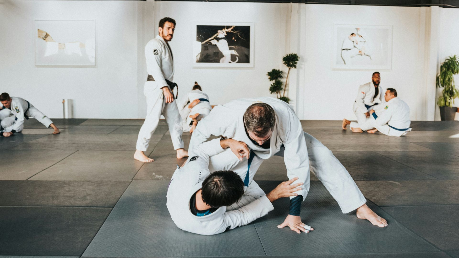 man in white long sleeve shirt and black pants sitting on black floor