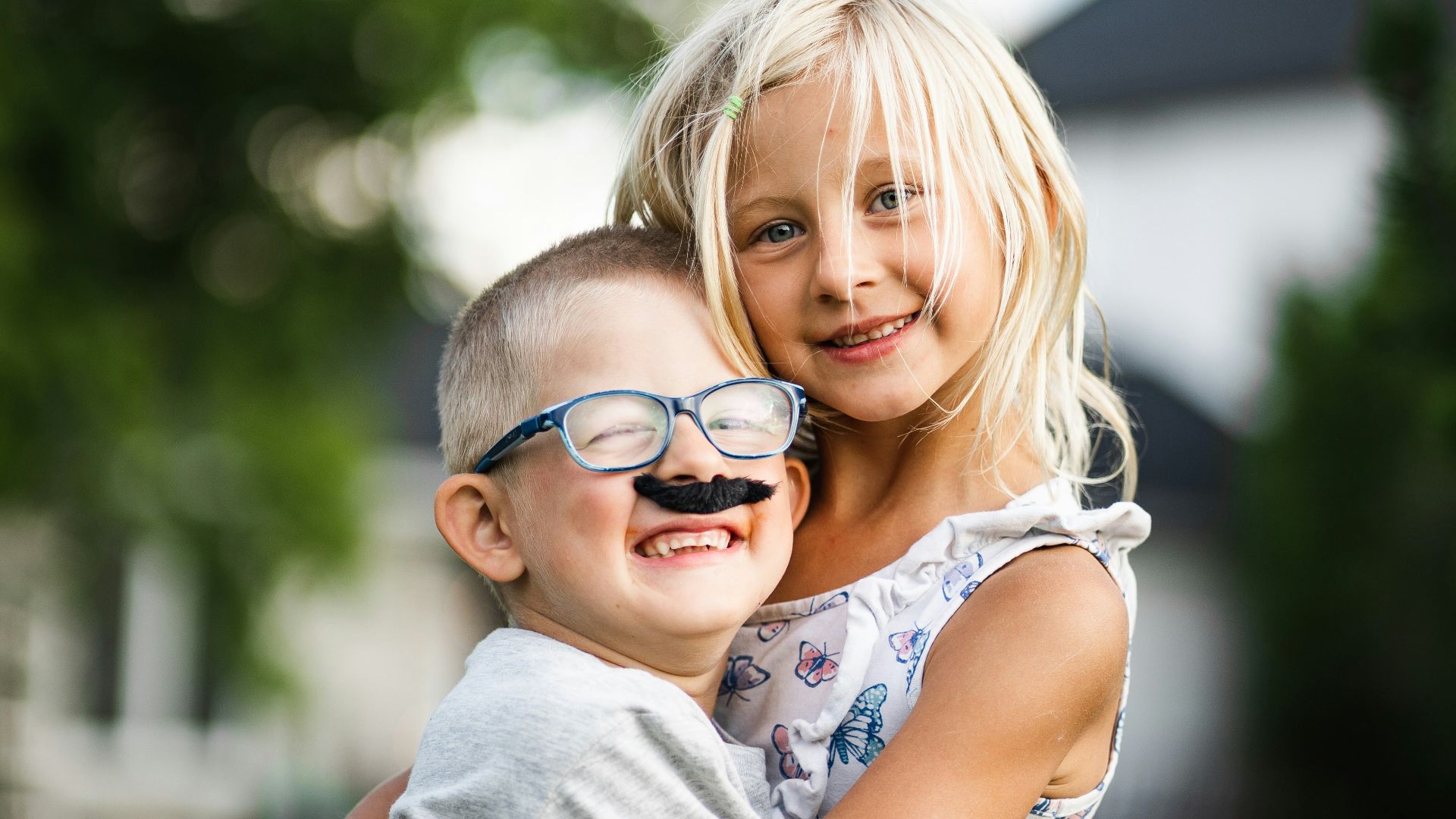 girl in white and blue floral dress wearing black framed eyeglasses