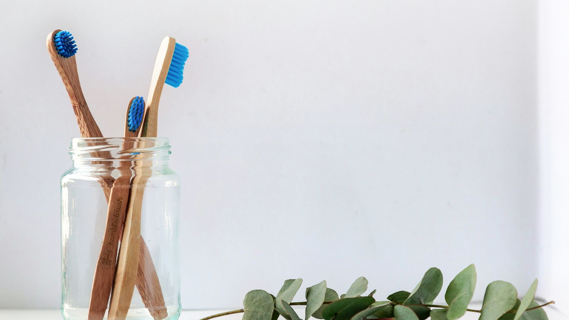 blue and white toothbrush in clear glass jar