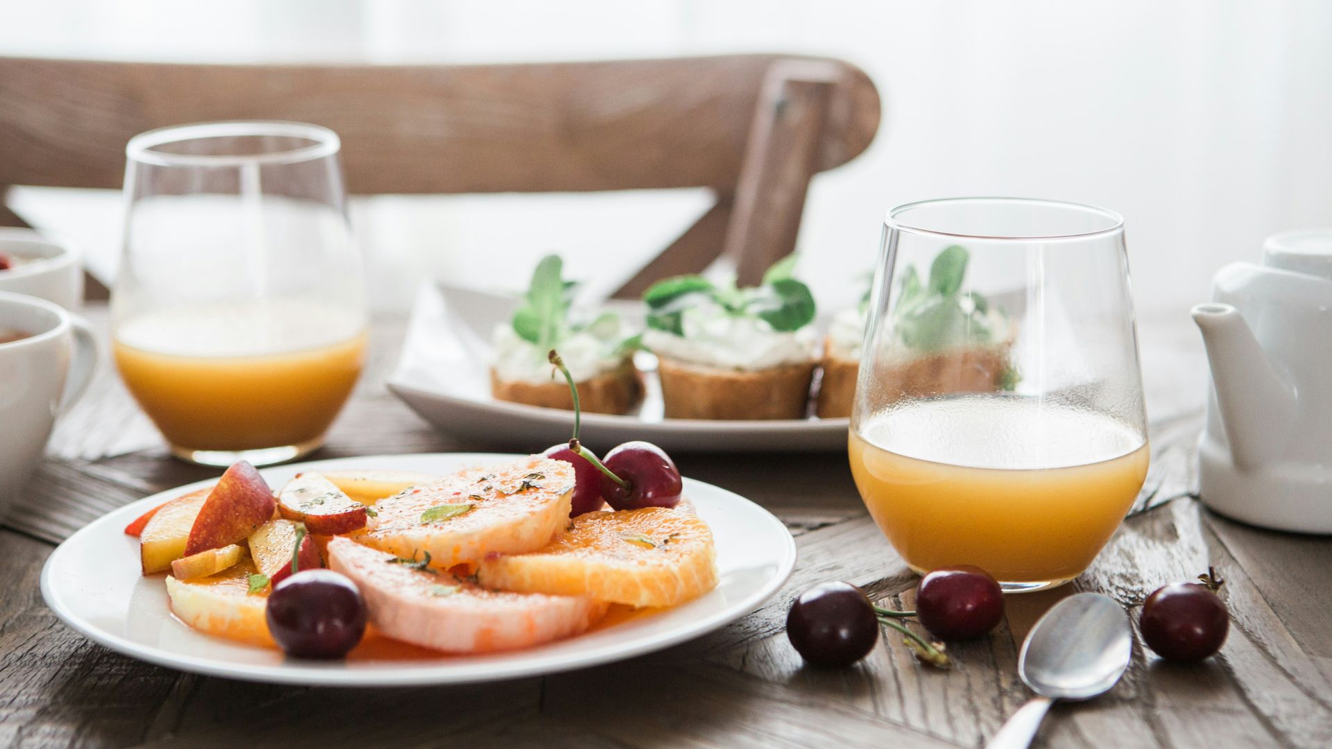 slice fruits on plate on near glass cups