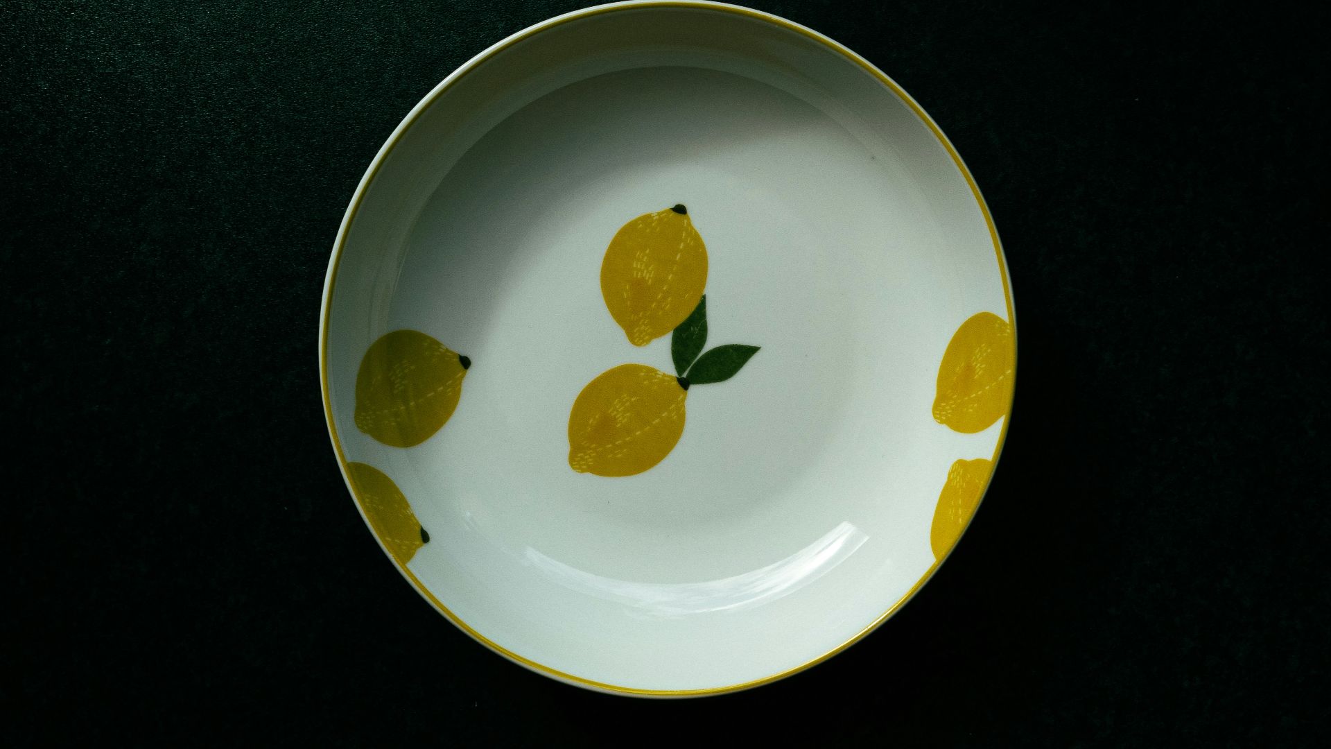 a yellow and white plate with lemons painted on it