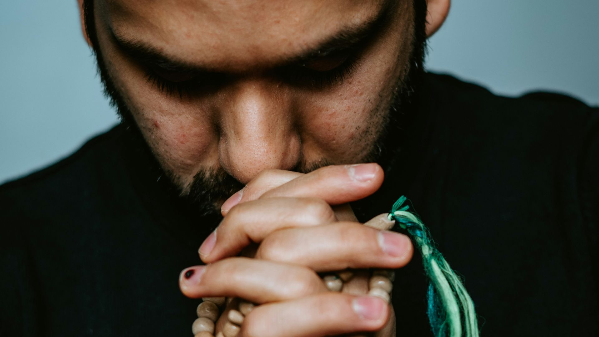 man in black crew neck shirt with silver chain necklace