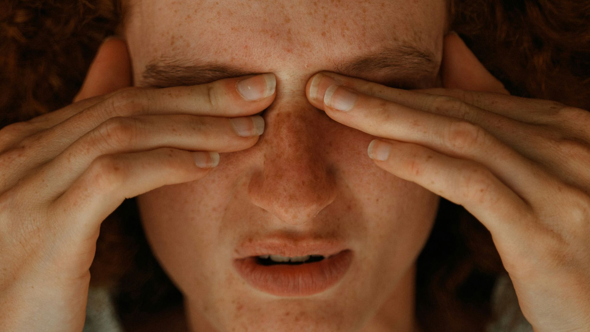 a woman with red hair covering her eyes